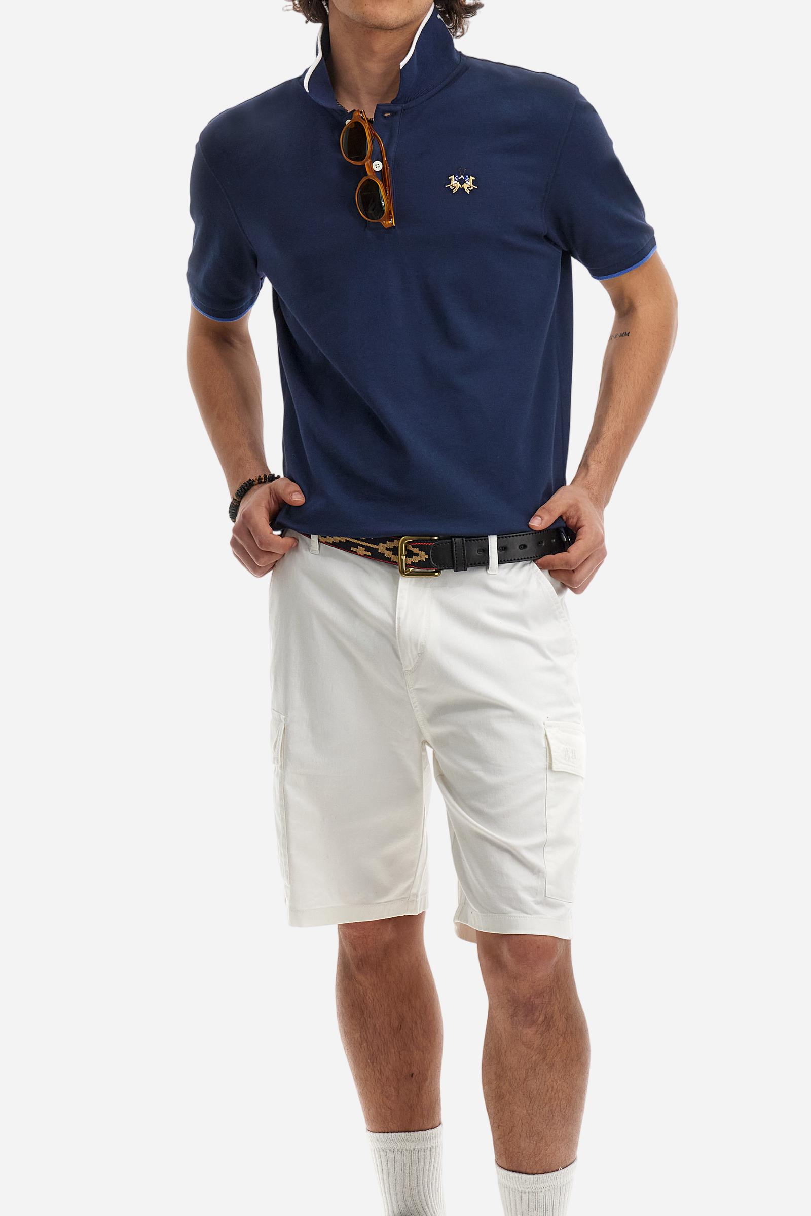 Short-sleeved, single-colour men's polo shirt made of stretch cotton piqué. Fastens with two buttons. The collar and cuffs are ribbed, and there is a colour-contrasting trim at the bottom of the collar. Inside the collar there is a grosgrain ribbon of a different shade. The logo is embroidered on the chest in a contrasting colour. The fit is slim. The model is wearing a size L. - Navy