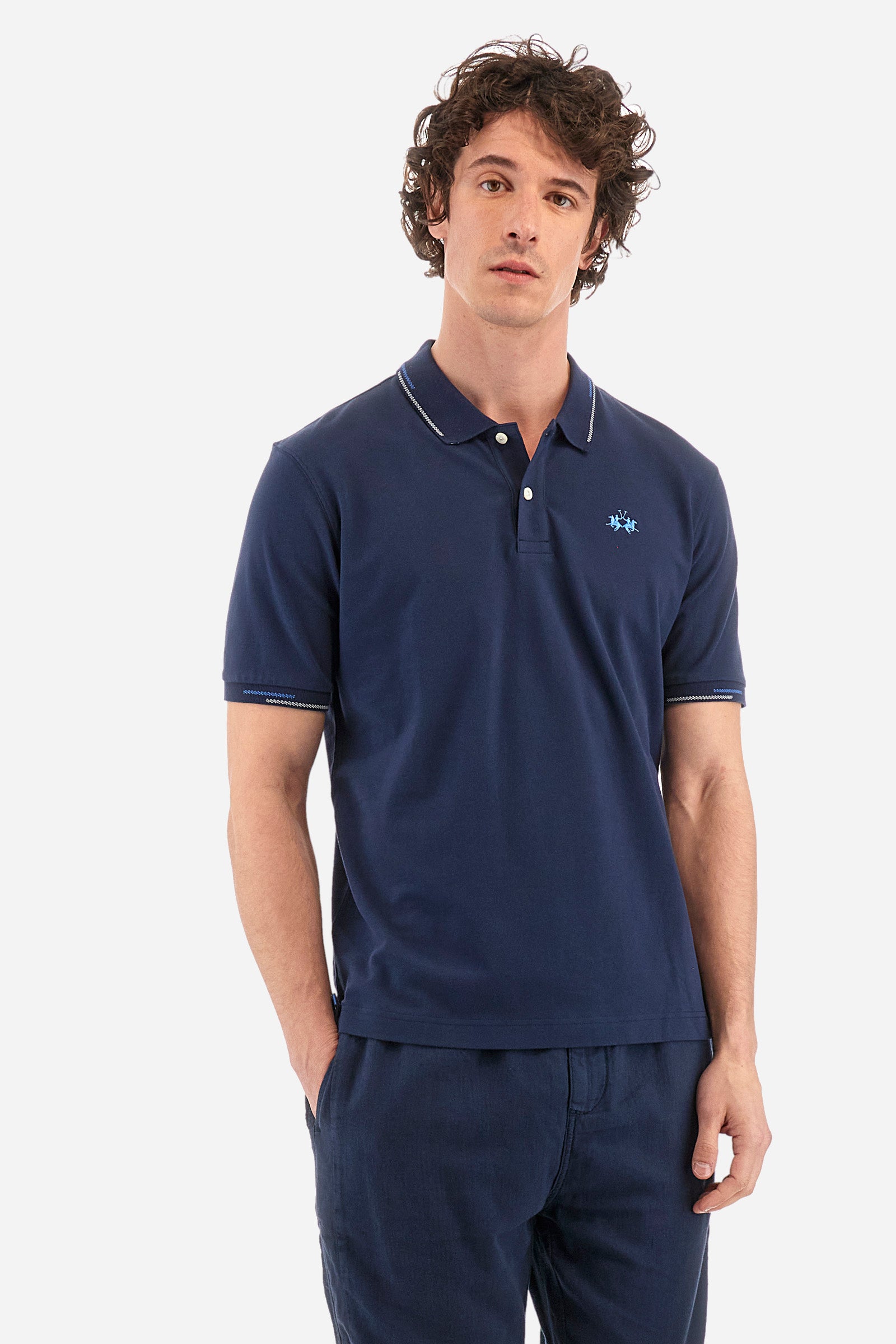 Men's single-colour short-sleeved polo in elasticated cotton. Two-button fastening. Ribbed collar and armholes with a stripe in different shades. Featuring a small logo embroidered on the chest. The fit is regular. The model wears a size L. - Navy