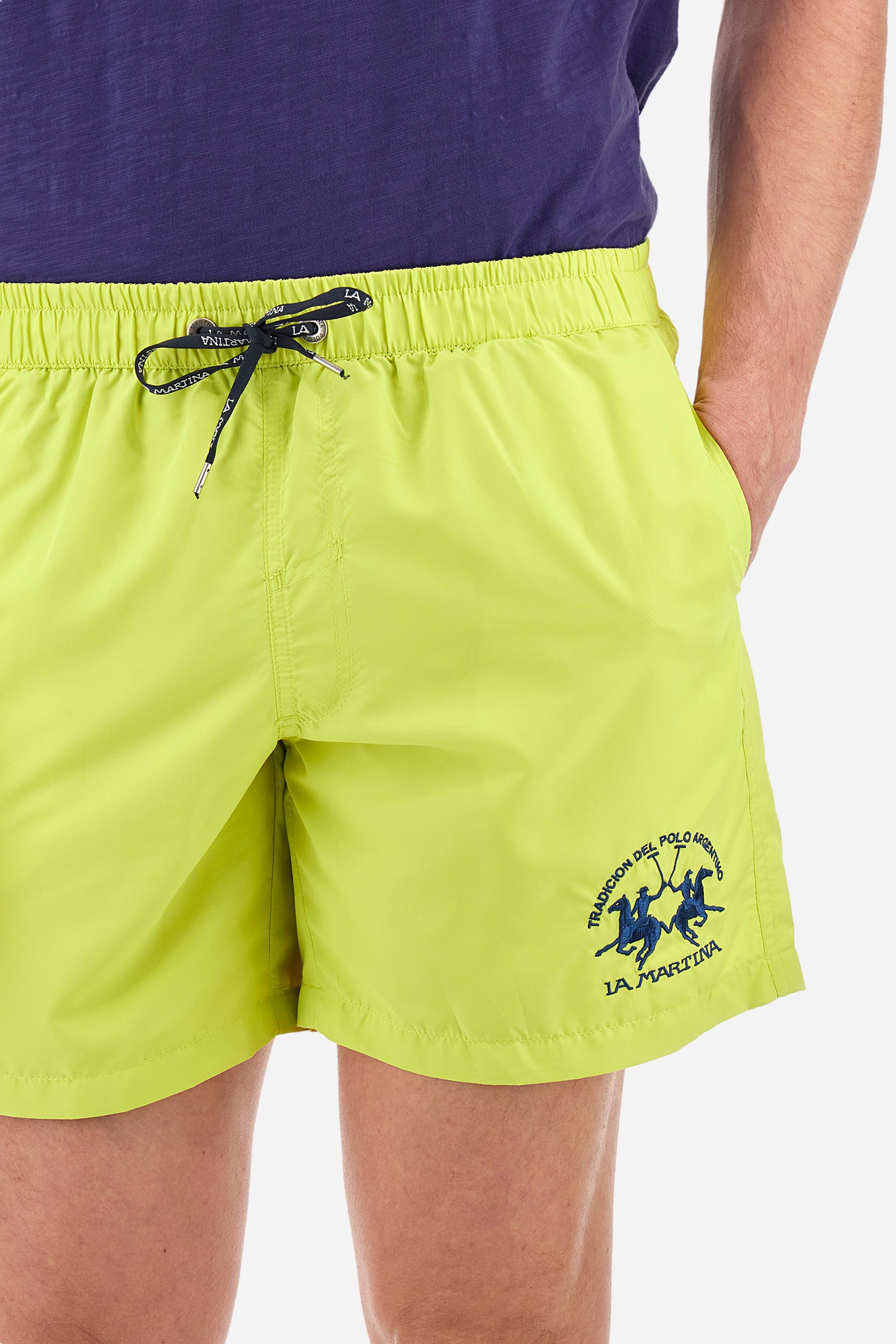 Single-colour men's swimming shorts, made of synthetic fabric. Featuring a drawstring and tie with "La Martina" lettering. Double welt pocket on the front. Closed pocket on the back. Mesh lining. Large logo embroidered on the front. The fit is regular. The model wears a size L. - Acacia