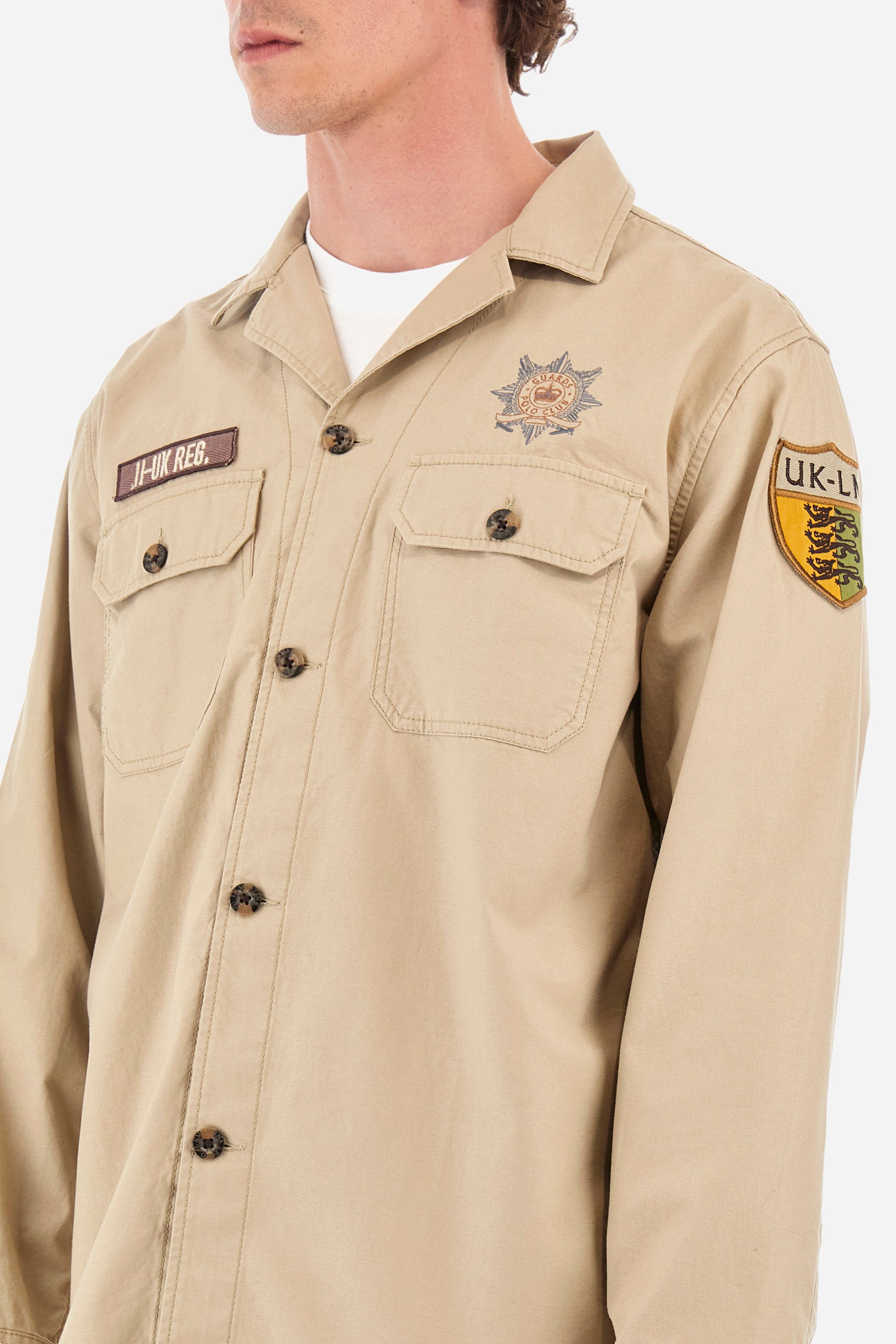 Men’s solid color shirt with long sleeves, Saharan style. Made of 100% cotton. Bowling collar. Cuffs with buttons. Patches applied on the sleeves and front identify the Guards capsule. Two pockets with button on the front. The fit is regular. The model wears a size L. - Tidal Foam