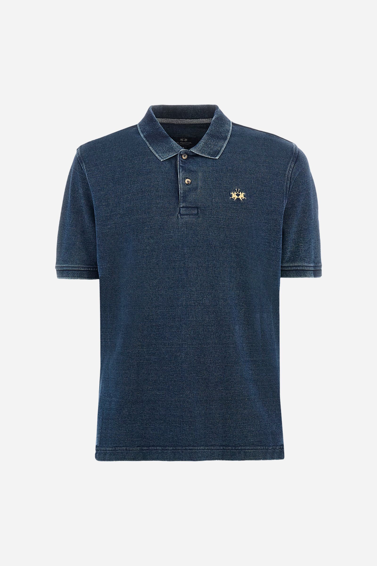 Men's short-sleeved polo shirt made of 100% cotton indigo pique. Fastens with two buttons. The collar and cuffs are folded and are made of ribbed fabric. Garment treated with enzyme washing, which gives the faded and lived-in look typical of denim. The contrasting embroidered logo is present on the left side of the chest. Regular fit. The model is wearing a size L. - Dark Indigo Denim