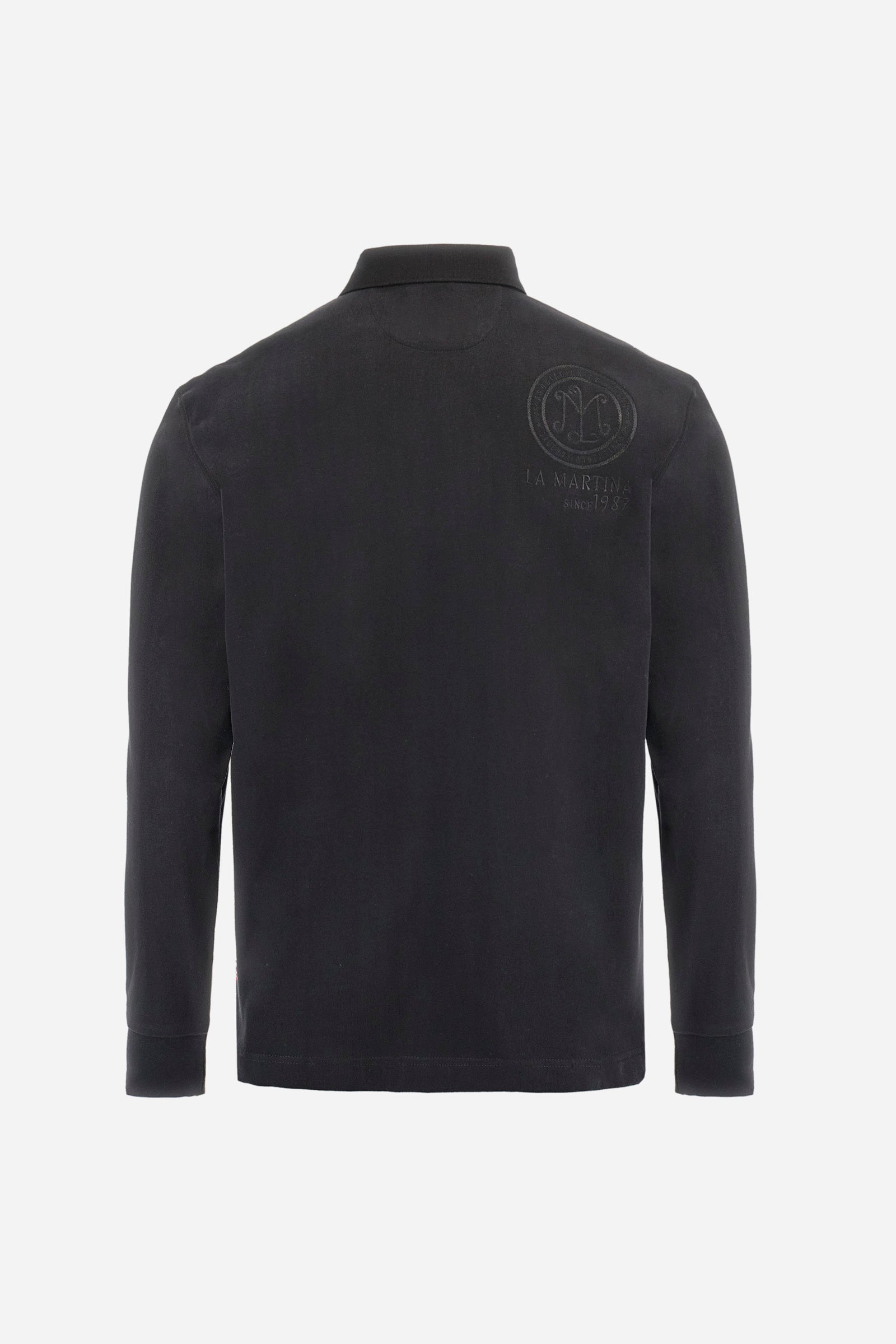 Long-sleeve polo shirt crafted from 100% high-quality cotton jersey. The velvety fabric offers a warm, cozy feel, perfect for cooler seasons. Ribbed collar and cuffs in matching tone, with a three-button personalized placket. A small multicolor embroidered logo sits below the opening, while tonal patches in different shapes and textures, inspired by Argentine culture and Gaucho tradition, decorate the chest and back. Classic regular fit. Model wears size L. - Black