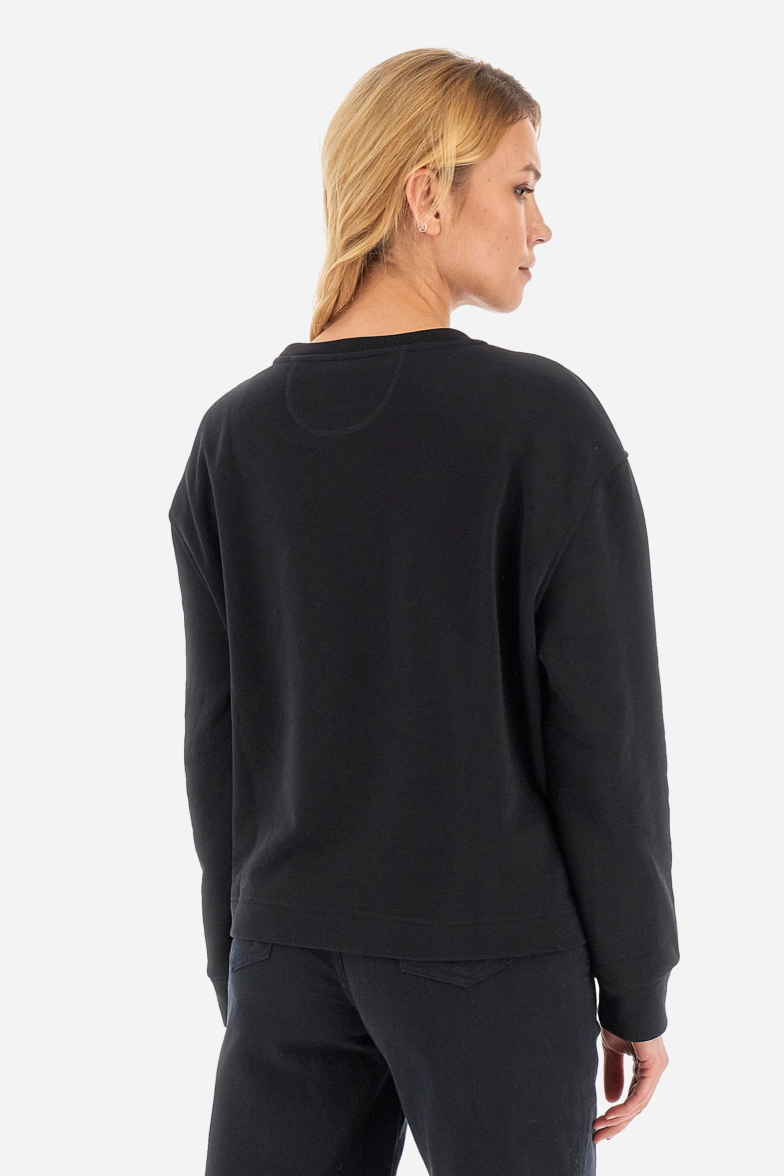 This women's crew-neck long-sleeved sweatshirt is made of a cotton blend fabric that is soft to the touch and comfortable to wear. With a regular fit, it is part of the Jet Set line and is characterised by a solid colour embellished by a large print featuring polo players and a print of the La Martina brand. Its simple and essential line makes it perfect for a casual and sporty look. The model is 174 cm tall and wears a size 2. - Black