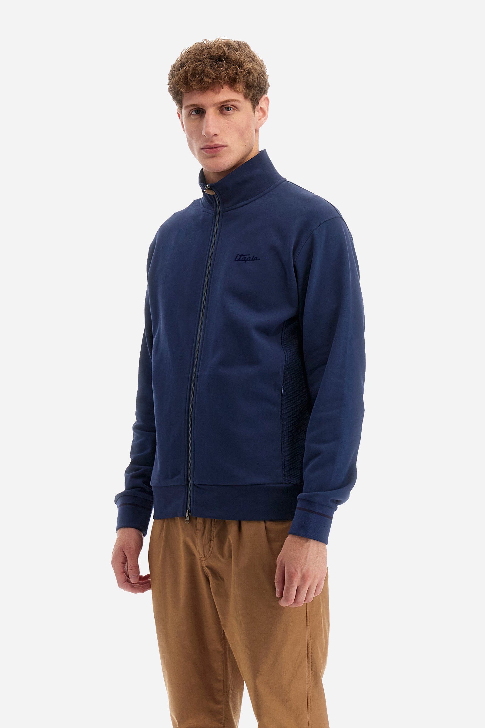 Single-colour long-sleeved men's sweatshirt with full zip fastening from the line in collaboration with Pagani. Made of 100% cotton. Mock neck, ribbed waistband and cuffs. Double back pocket. On the sides the garment has a different texture from the main part. There is lettering on the front, while a plate featuring the La Martina logo and the Pagani logo is sewn on the back. The fit is regular. The model wears a size L. - Ensign Blue