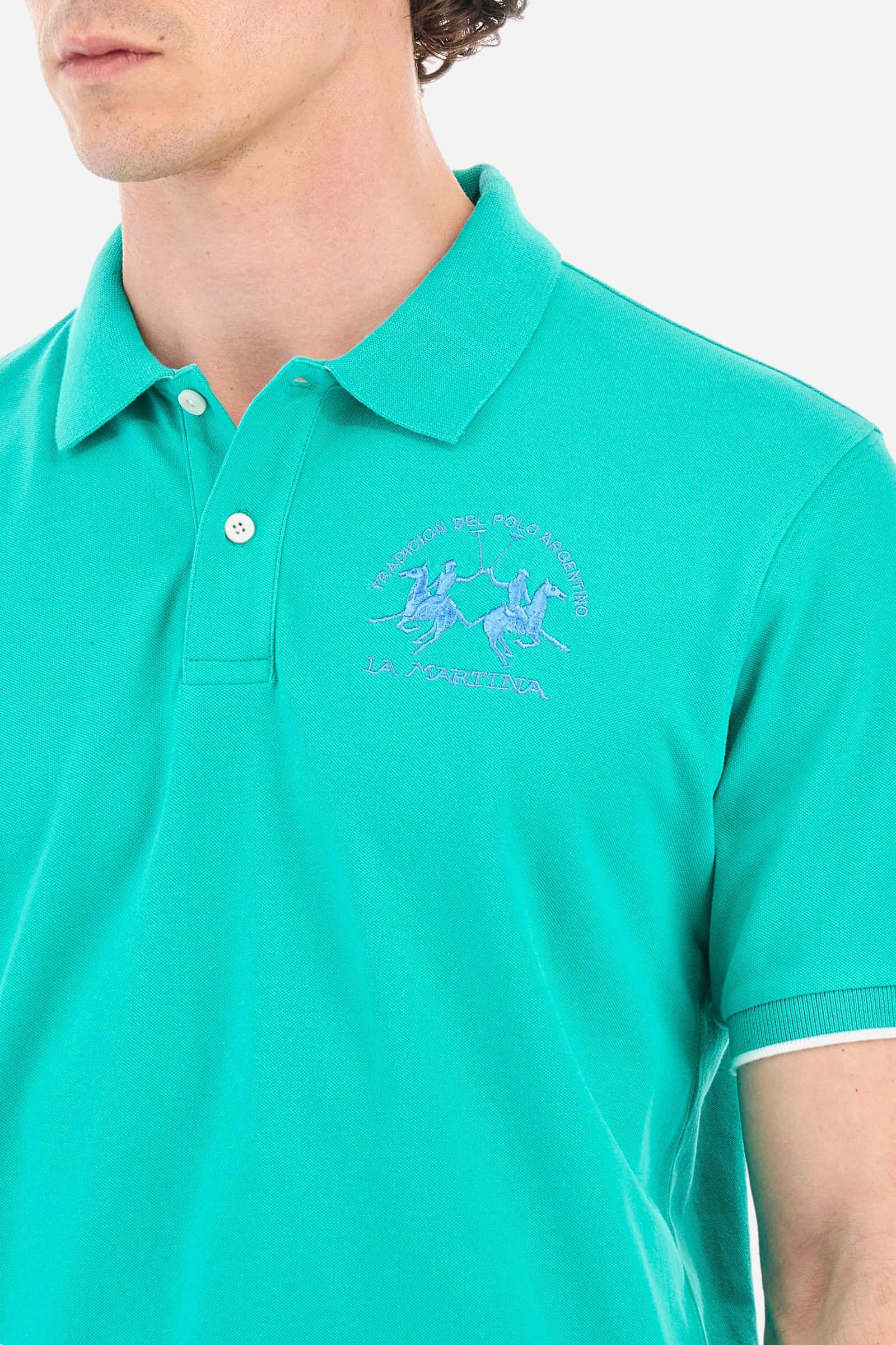 Men’s polo with short sleeves, regular fit. Made of stretch pique cotton. Classic model, with large embroidered logo in contrasting tone on the chest and profiled sleeve edges. The collar is accompanied by the writing La Martina, in contrasting tone. Ideal if worn with a denim collection. The model wears a size L. - Vivid Green