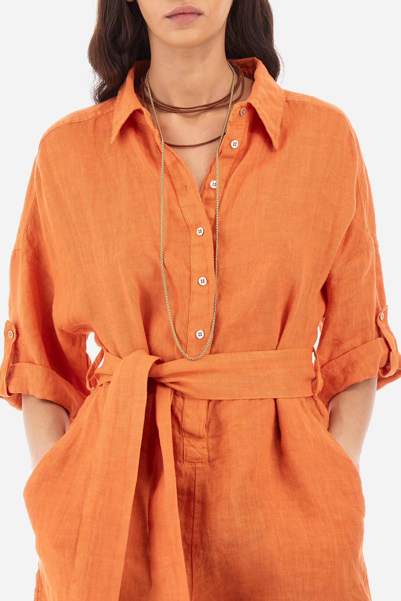 Women's one-piece playsuit with 3/4 sleeves with cuff and single-colour shorts. In 100% linen. French collar. With button fastening. Belt loops and fabric belt included. Featuring two front welt pockets and two back pockets. A logo and the lettering "La Martina" are embroidered on the back. The fit is regular. The model wears a size IT40. - Celosia Orange