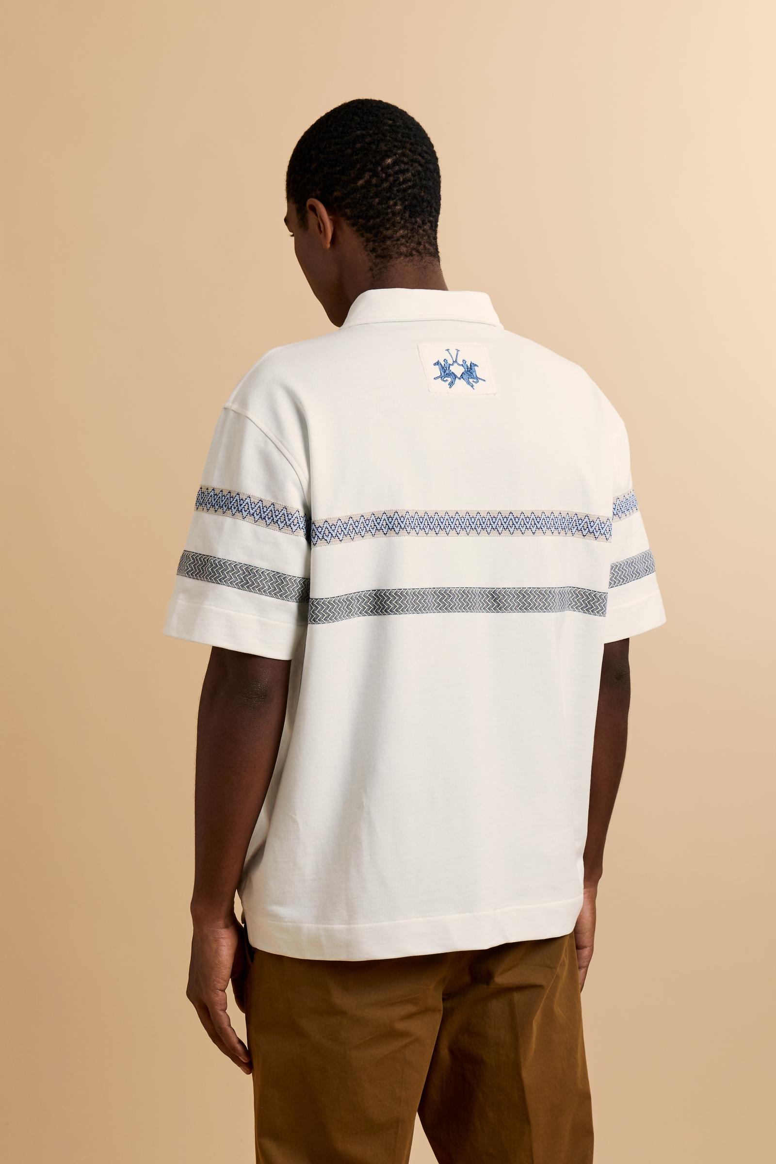 Short-sleeve polo in heavy cotton jersey with a compact structure and substantial hand feel. Contemporary fit with relaxed volume and slightly dropped shoulders. Classic collar with visible placket and bold horizontal band with geometric multicolor tapes. Raised “La Martina” embroidery on the chest and contrasting 3D logo on the back. - Off White