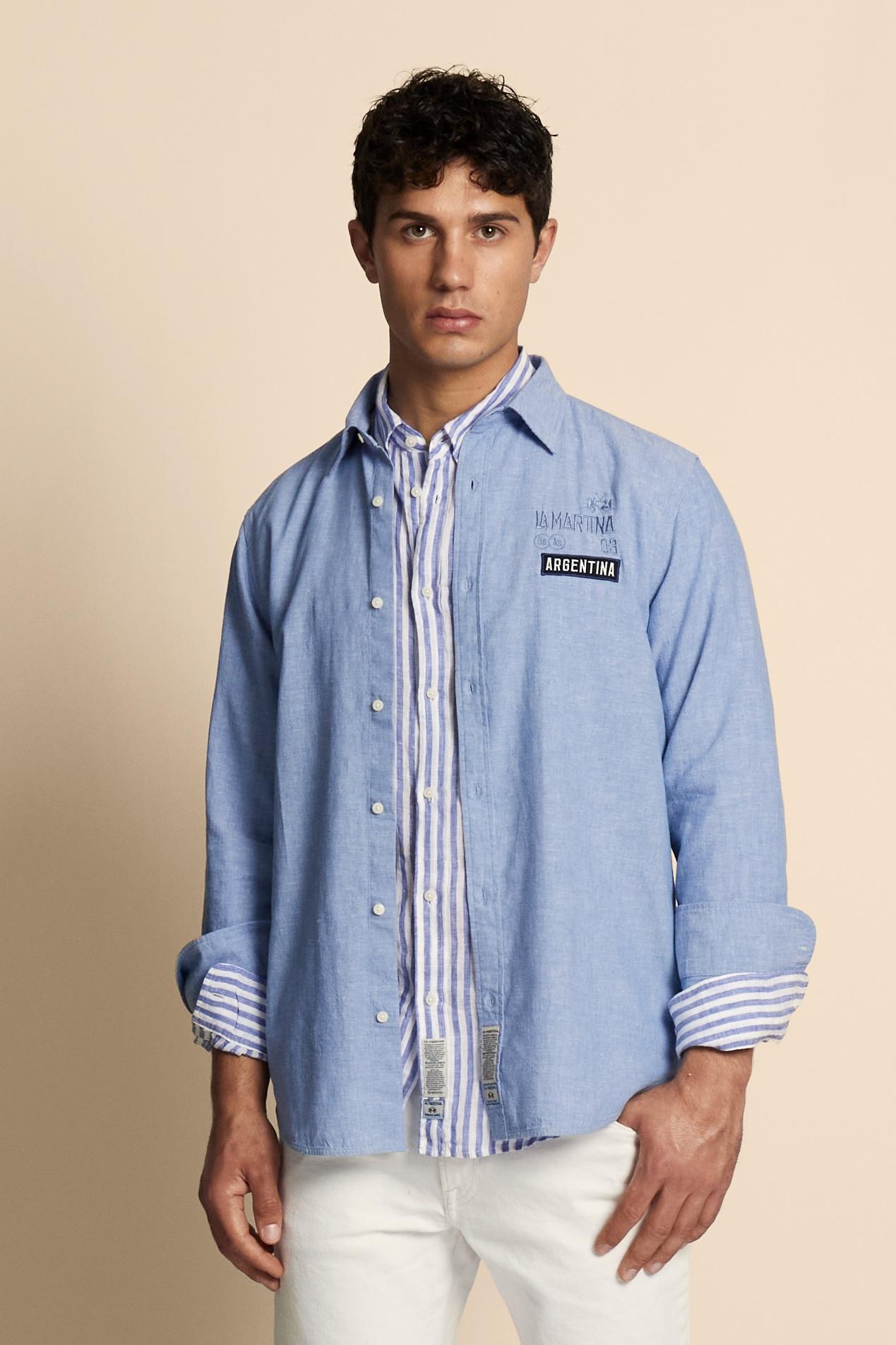 Men’s long-sleeve shirt in premium natural cotton and linen blend, lightweight and breathable with the typical slub texture of linen. The classic cut with regular fit, pointed collar, adjustable cuffs and slightly rounded hem ensures comfort and versatility. Printed and embroidered graphics define the character of the piece: the back features the maxi “Polo Player Argentina” lettering with numeric and technical logo details, while contrasting patches decorate the front. The model wears size L. - Cornflower