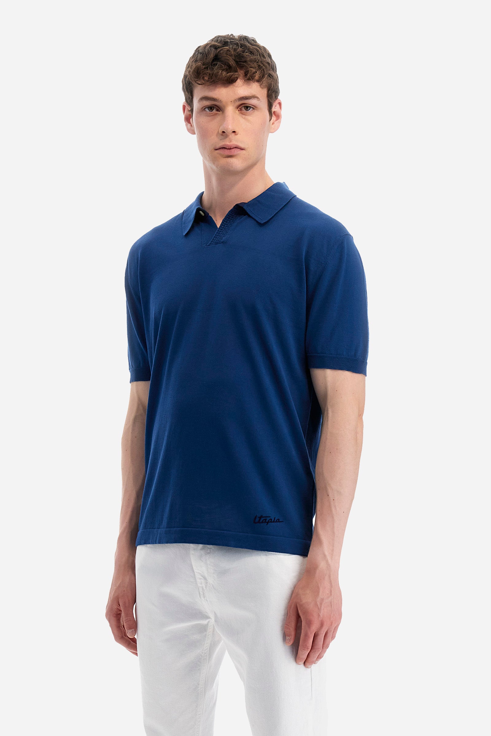 Single-colour men's knitted polo shirt with short sleeves from the line in collaboration with Pagani. Made of 100% cotton. Fastens with a button. Ribbed armholes and waist. The logo and "La Martina" and "Pagani" lettering are present on the patch representing the collaboration applied on the back. The fit is regular. The model wears a size L. - Ensign Blue
