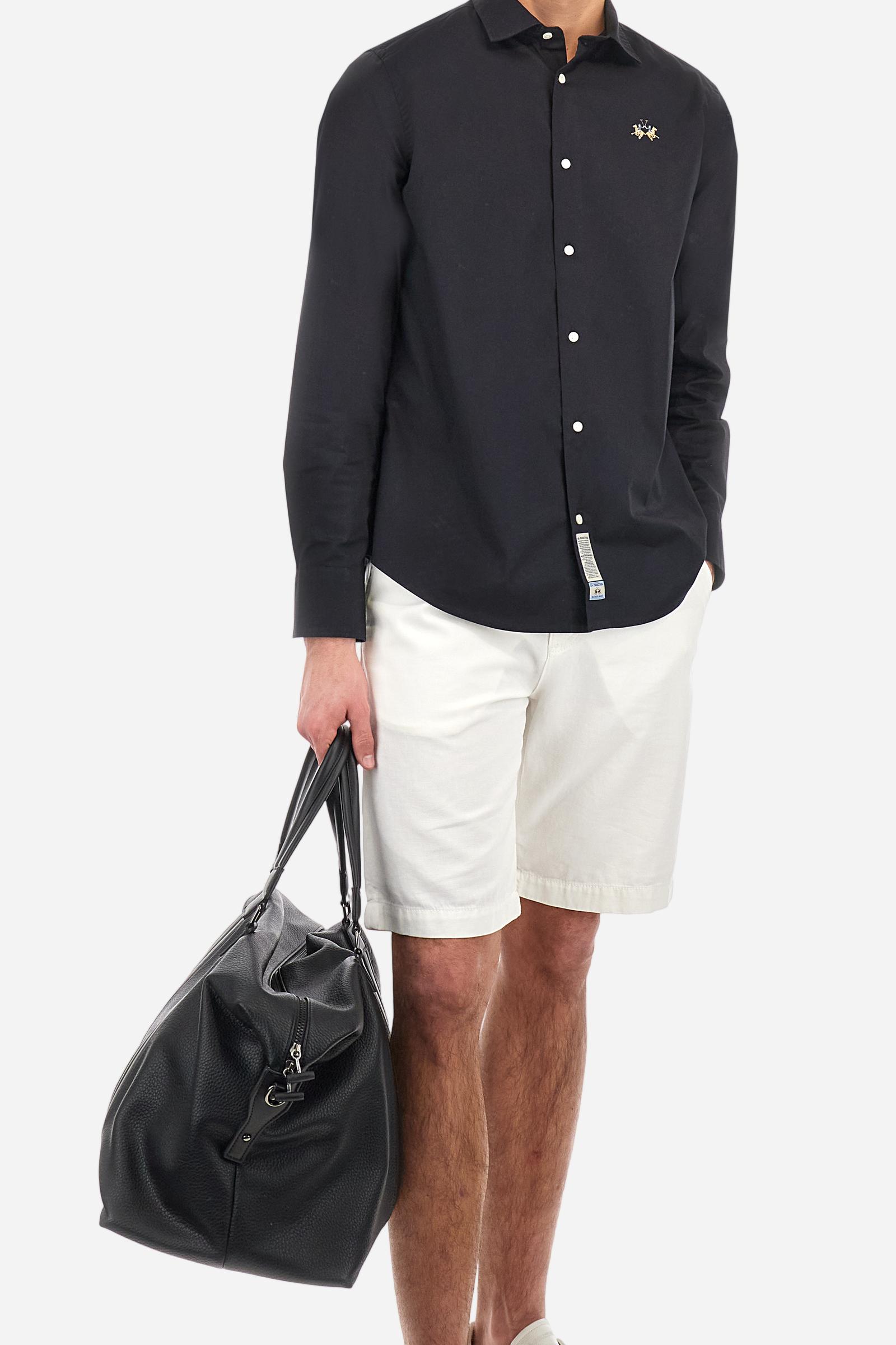 Men's single-colour long-sleeved shirt, made from 100% cotton poplin. Spread collar. The tricolour logo embroidery is on the chest, left side. The fit is slim. The model is wearing a size L. - Black