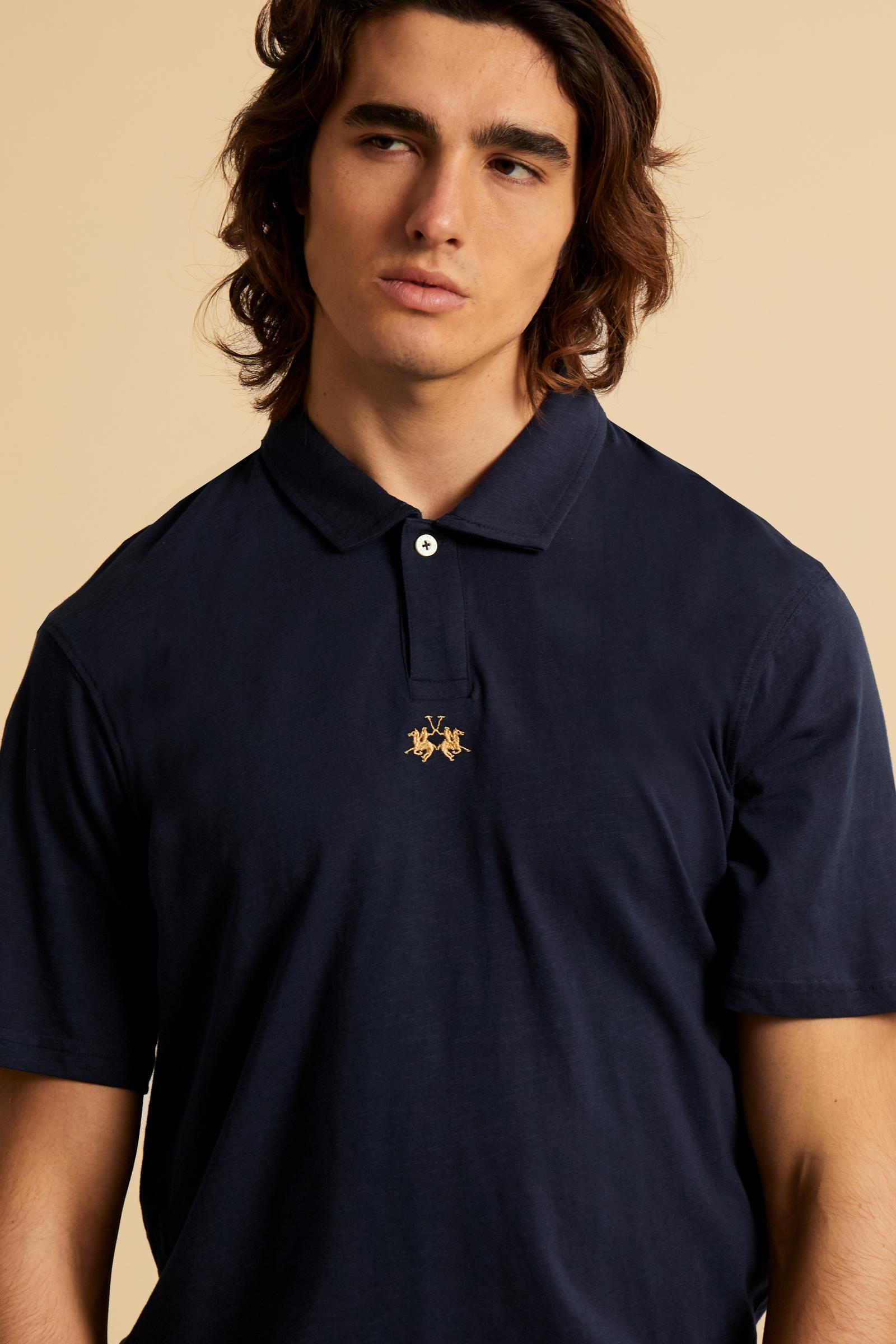 This is the iconic Polo 19-42 from La Martina. Men's short-sleeved polo shirt in solid color made of 100% slub jersey. With a regular fit, it has a collar and a double button closure while the La Martina logo is embroidered in small gold on the front under the placket. Ideal when worn with denim from the collection. Each Polo is kept in an exclusive logoed envelope and is accompanied by a certificate of guarantee. The model is 187 cm tall and wears a size L. - Navy