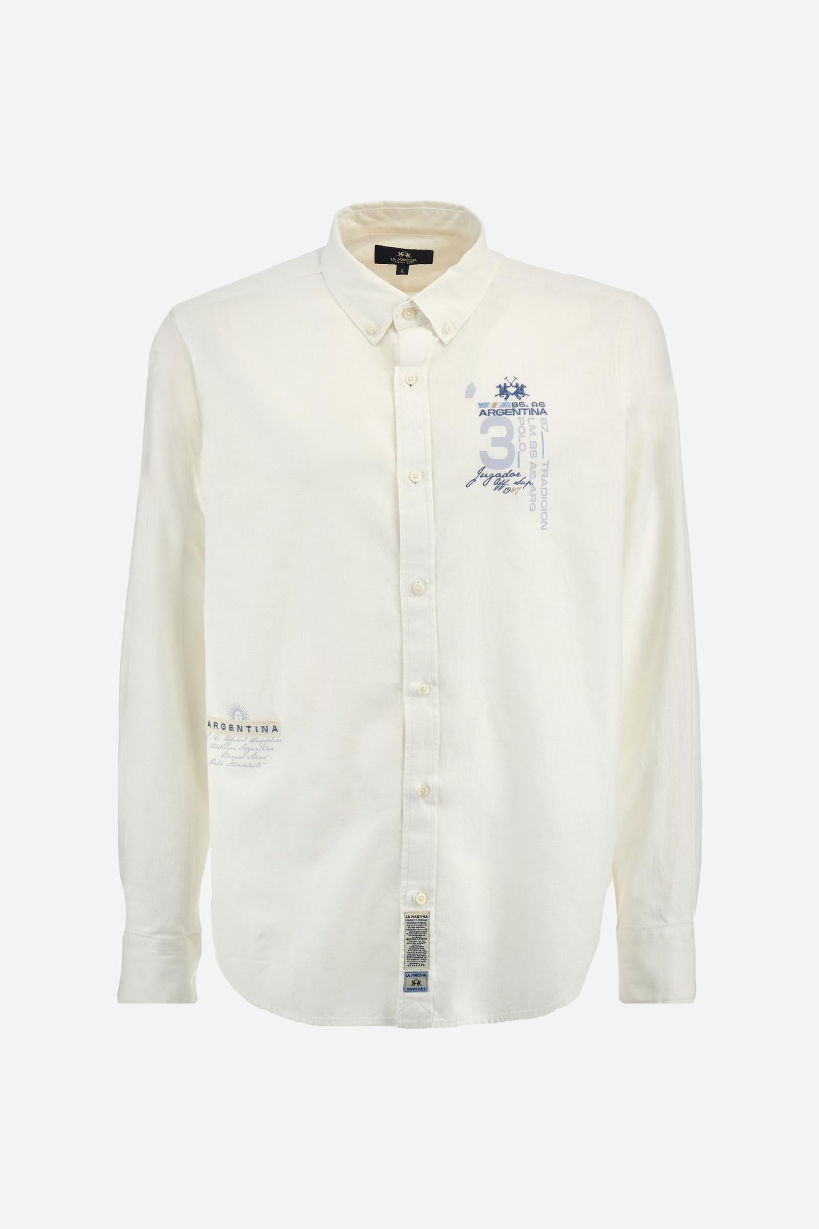 Men's plain long-sleeved shirt made from cotton and linen canvas. Featuring a button-down collar and sleeve openings embellished with contrasting fabric details. The graphic on the chest, over the heart, is created using a combination of embroidery and printing techniques to add a distinctive touch. On the side, at the front, there is a ribbon embroidered with the word Argentina, topped with a print. Regular fit. The model is wearing a size L. - Optic White