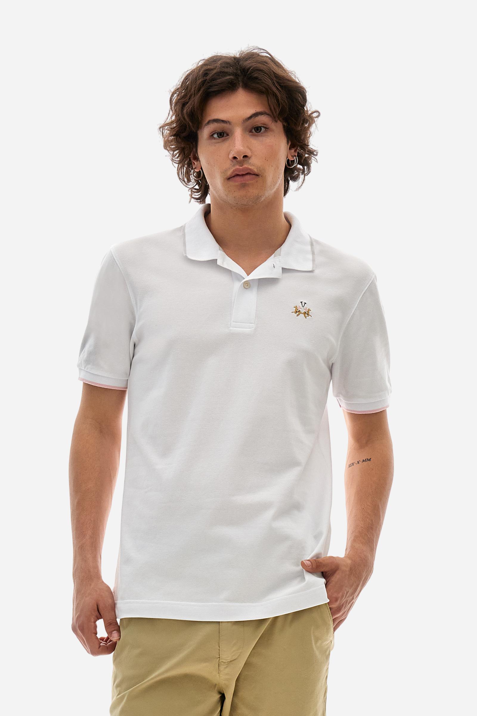 Short-sleeved, single-colour men's polo shirt made of stretch cotton piqué. Fastens with two buttons. The collar and cuffs are ribbed, and there is a colour-contrasting trim at the bottom of the collar. Inside the collar there is a grosgrain ribbon of a different shade. The logo is embroidered on the chest in a contrasting colour. The fit is slim. The model is wearing a size L. - Optic White