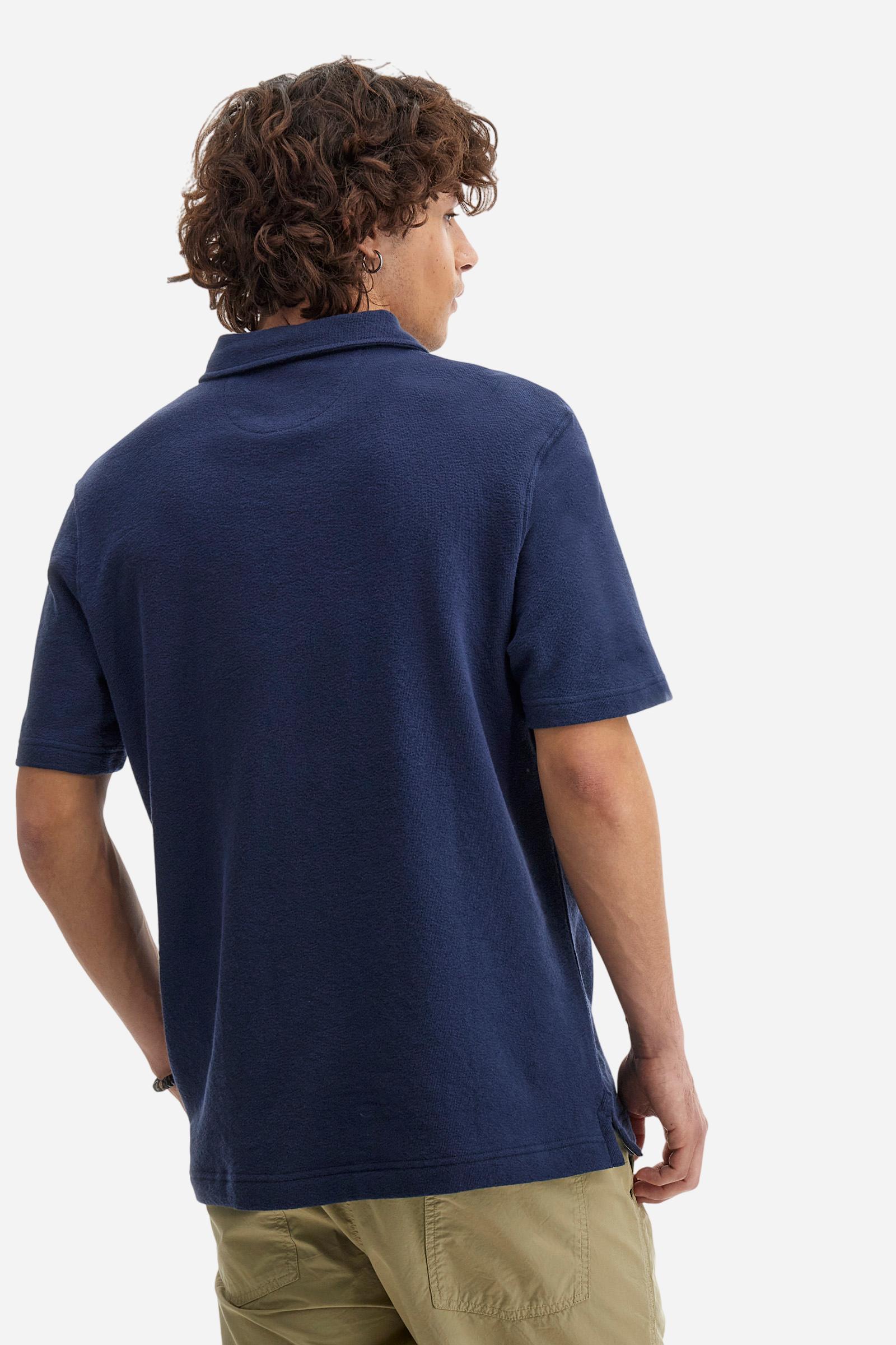 Men's plain short-sleeved polo shirt made from brushed jersey. Three-button fastening. The embroidery on the left side of the chest, in contrasting thread, is inspired by the French Riviera. A small logo is embroidered on the left sleeve, also using contrasting thread. Regular fit. The model is wearing a size L. - Navy