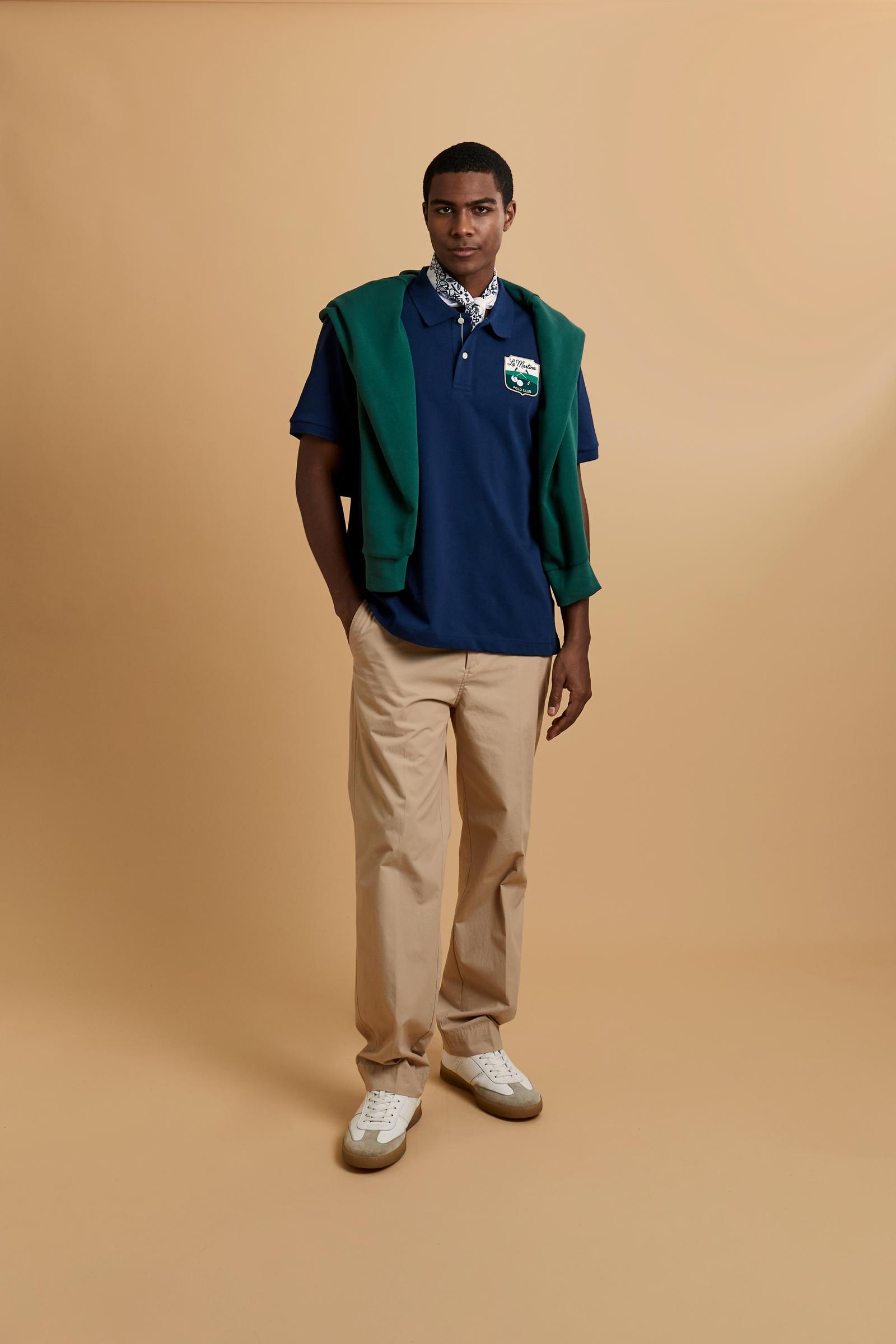 Men’s short-sleeve cotton piqué polo. Two-button placket and contemporary fit, featuring an applied shield patch on the chest and large lettering on the back. - Navy