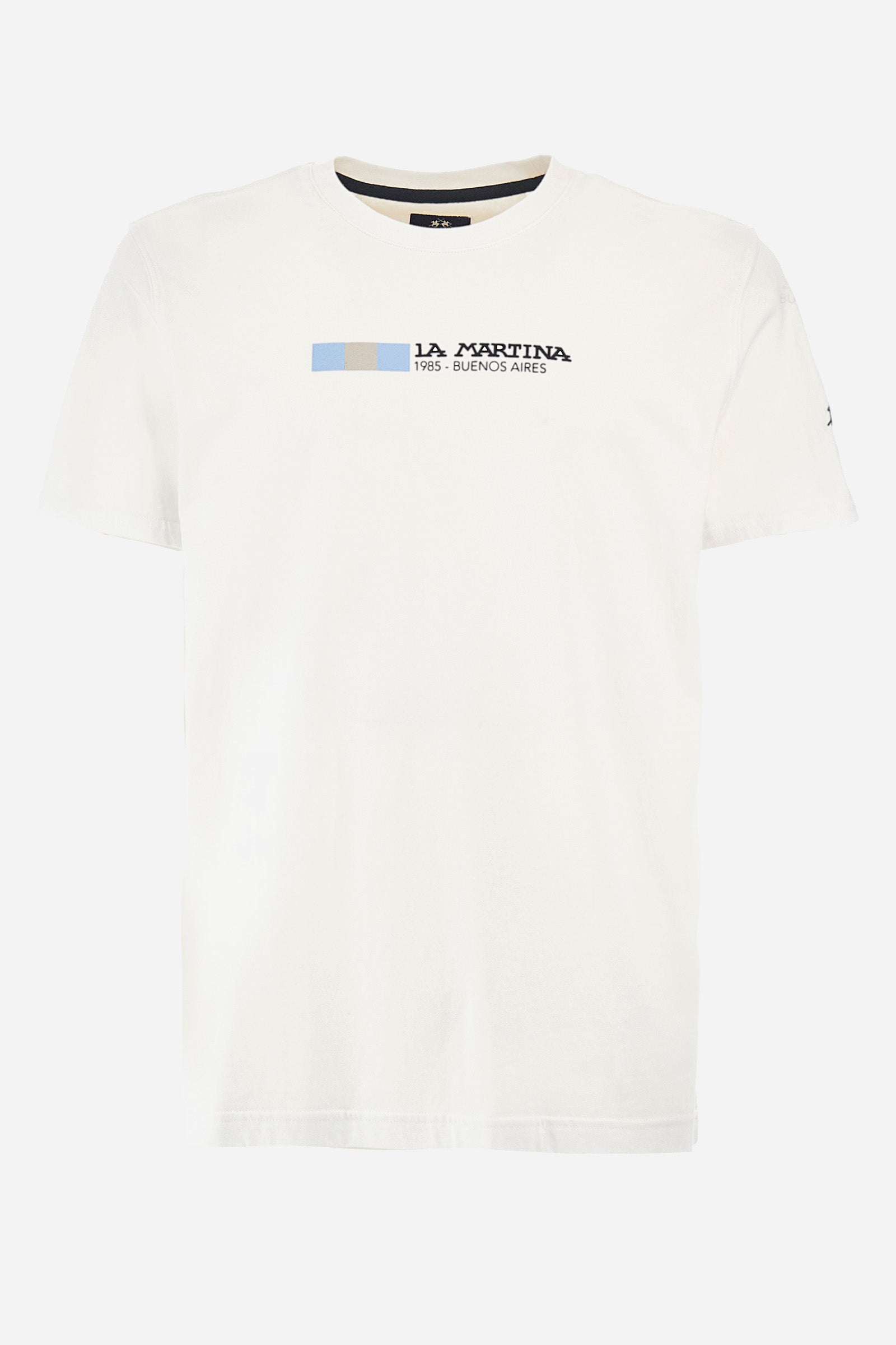Men's short-sleeved T-shirt with a crew neck in a single colour. Made of 100% cotton. On the front we find the lettering "La Martina 1985- Buenos Aires" with the Argentinian flag. A small logo is embroidered on one of the sleeves. Regular fit. The model wears a size L. - Optic White