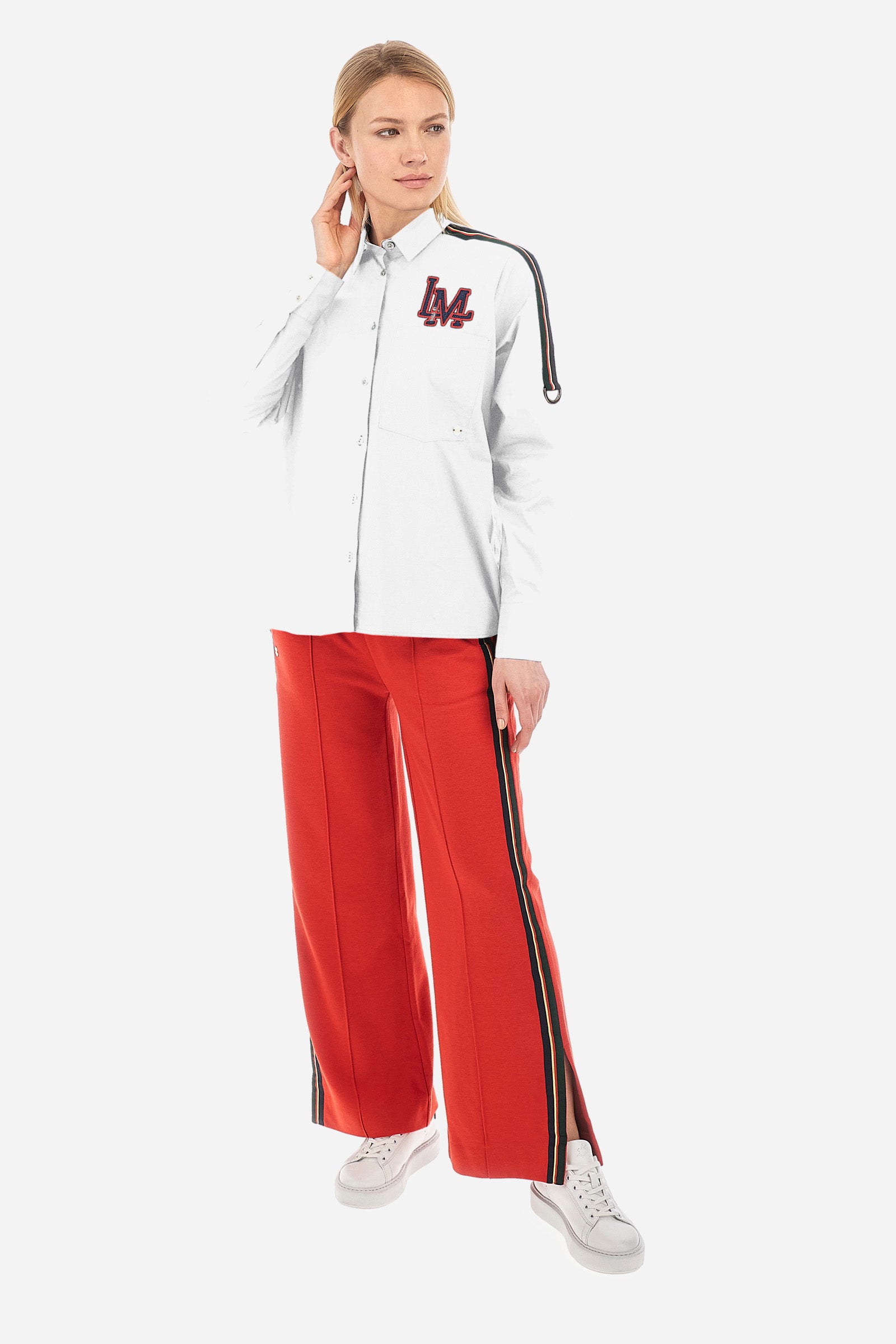 Solid-coloured long-sleeved women's shirt, made of stretch cotton with a regular fit. The line is Polo Academy and features a classic collar with button fastening. The chest is embellished with the LM patch and on the shoulders there is a contrasting band applied with a final ring. Finally, the shirt has a front pocket for added practicality. The model is 174 cm tall and wears a size 2. - Optic White