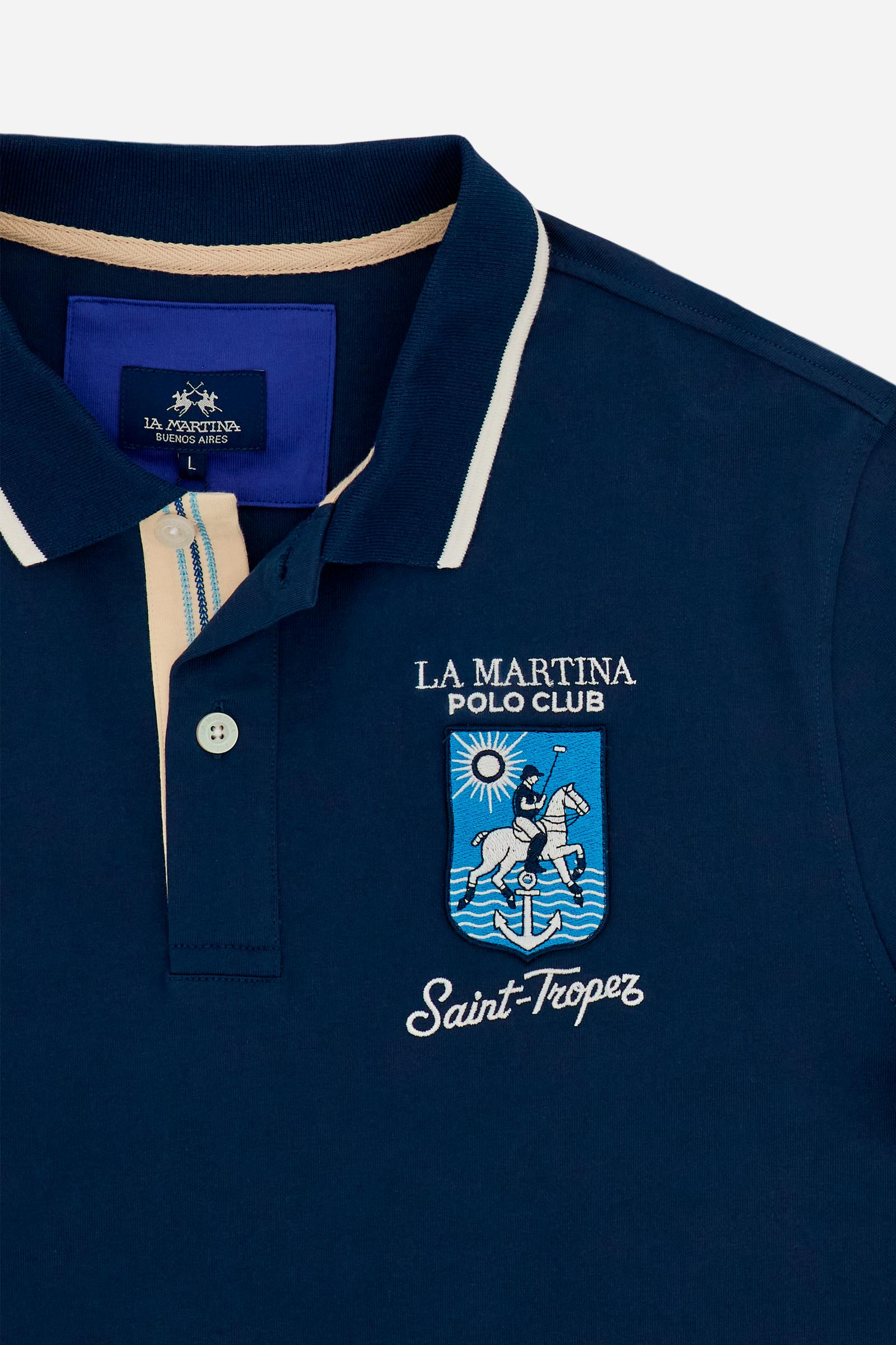 Men's short-sleeve polo shirt made from heavy-weight cotton jersey in solid color. The model features a front opening in contrasting jersey with vertically embroidered chain stitching. The collar and cuffs are ribbed with contrasting edge detail. The design is enriched with an embroidered crest on the chest dedicated to Saint Tropez and the iconic two polo players logo embroidered on the back. The fit follows modern trends with a slightly oversized silhouette, dropped shoulders and a relaxed shape. The mode