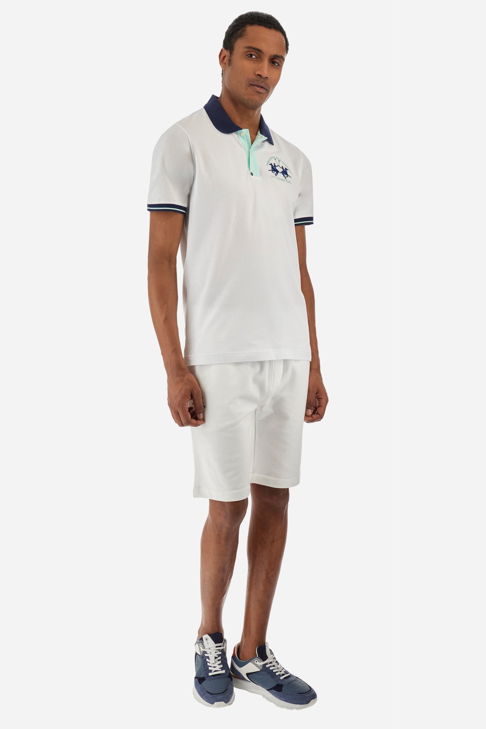 Men's single-colour short-sleeved polo in elasticated cotton. Fastens with two contrasting buttons. Ribbed collar and armholes in different shades. The "La Martina" lettering can be found under the collar. A large logo is embroidered on the chest. The fit is slim. The model wears a size L. - Optic White