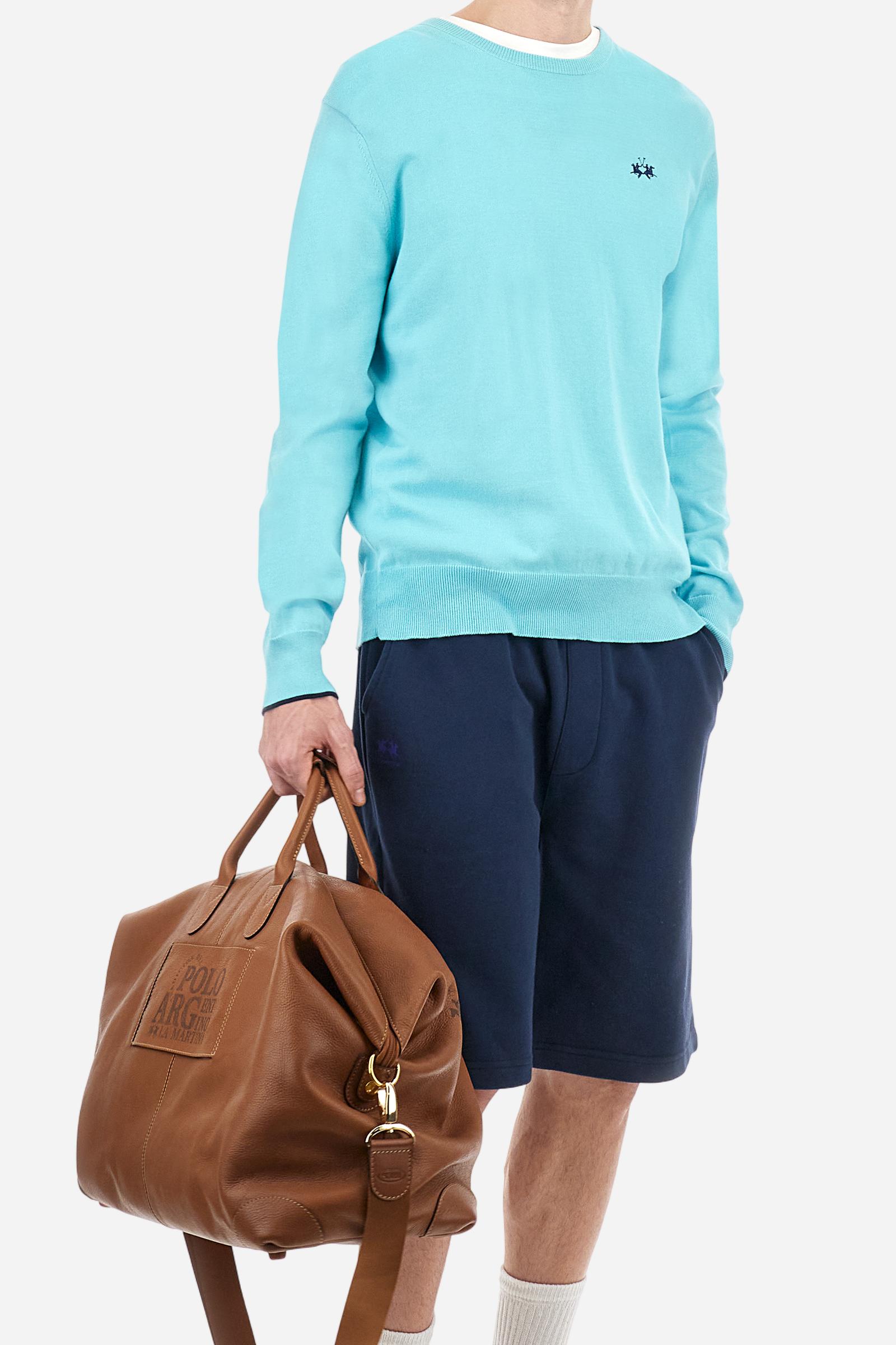 Men's plain long-sleeved pullover made of 100% combed cotton yarn. The collar is in two-tone ribbed knit: the exterior features the same tone as the jumper while the interior is in contrast. The cuffs and the band at the bottom are also made of ribbed knit. The cuffs also feature a contrasting stripe on the edge as a decorative motif. The logo is embroidered on the left side of the chest in contrasting thread. Regular fit. The model is wearing a size L. - Tanager Turquoise