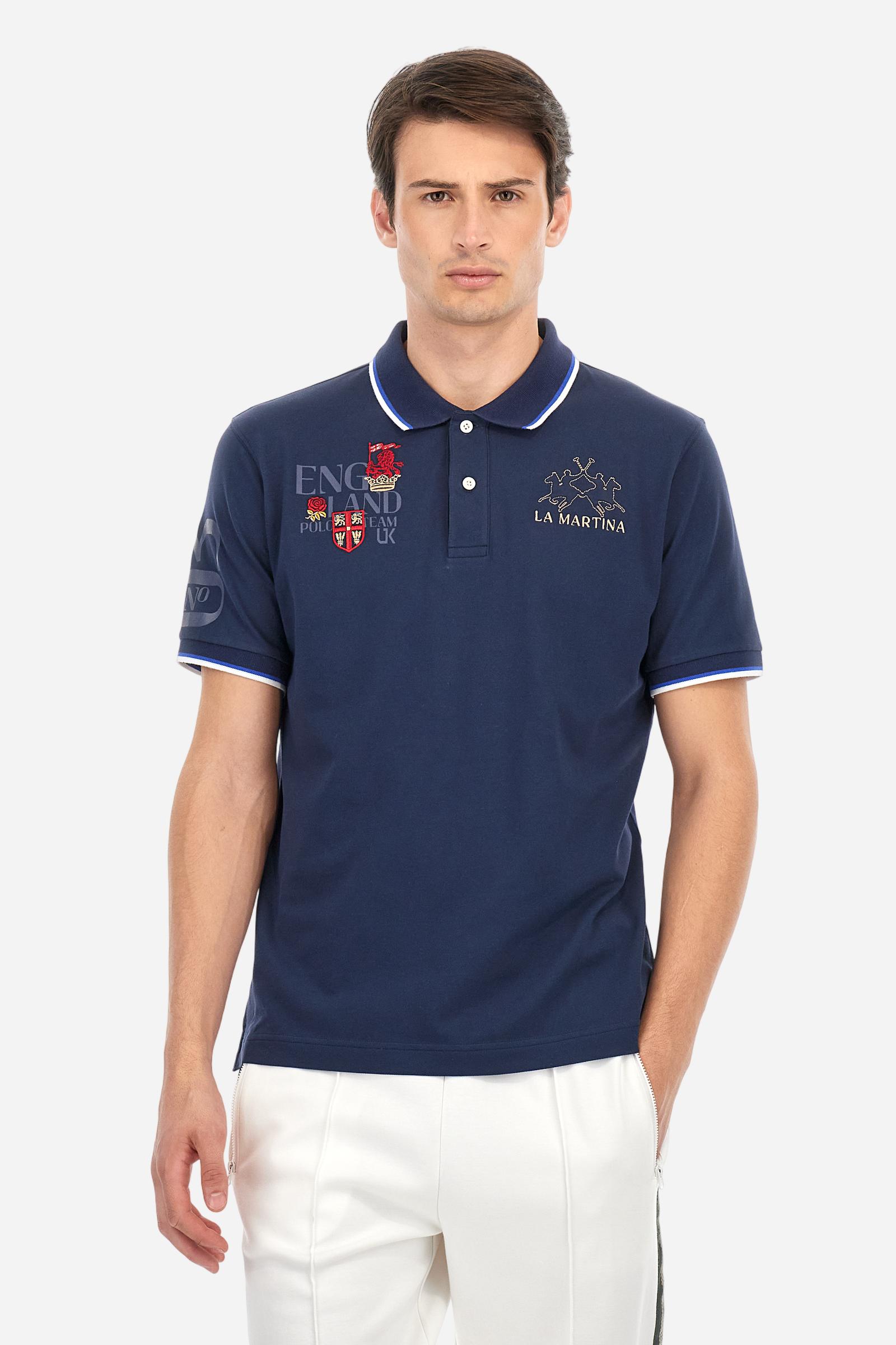 Men's solid color polo shirt, made of slightly elasticated cotton piqué. Two-button closure. Ribbed collar and sleeve hems, with a contrasting two-tone detail at the bottom of the sleeves. The entire garment features details crafted using mixed techniques. Both the front and back display embroidery and prints. The logo and the La Martina lettering are embroidered on the left chest. The fit is regular. The model is wearing size L. - Navy
