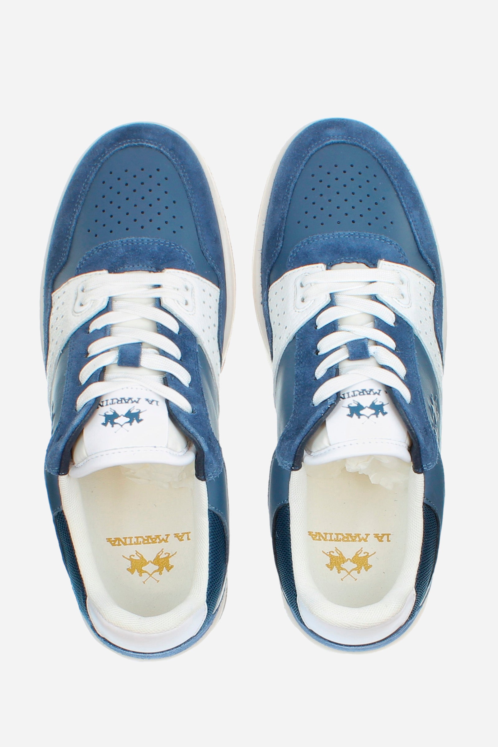 Vintage basketball shoe made from a mix of soft leather, suede and contrasting leather inserts, with a raised and cushioned two-tone rubber sole. The design is enriched by the iconic perforation motif on the toe and side. The La Martina logo is printed on the tongue, while the Field 85 logo appears printed on the patch. The STROBEL construction ensures superior comfort, flexibility and adaptability to the foot, offering a comfortable and stylish shoe. - AVIO/AVIO