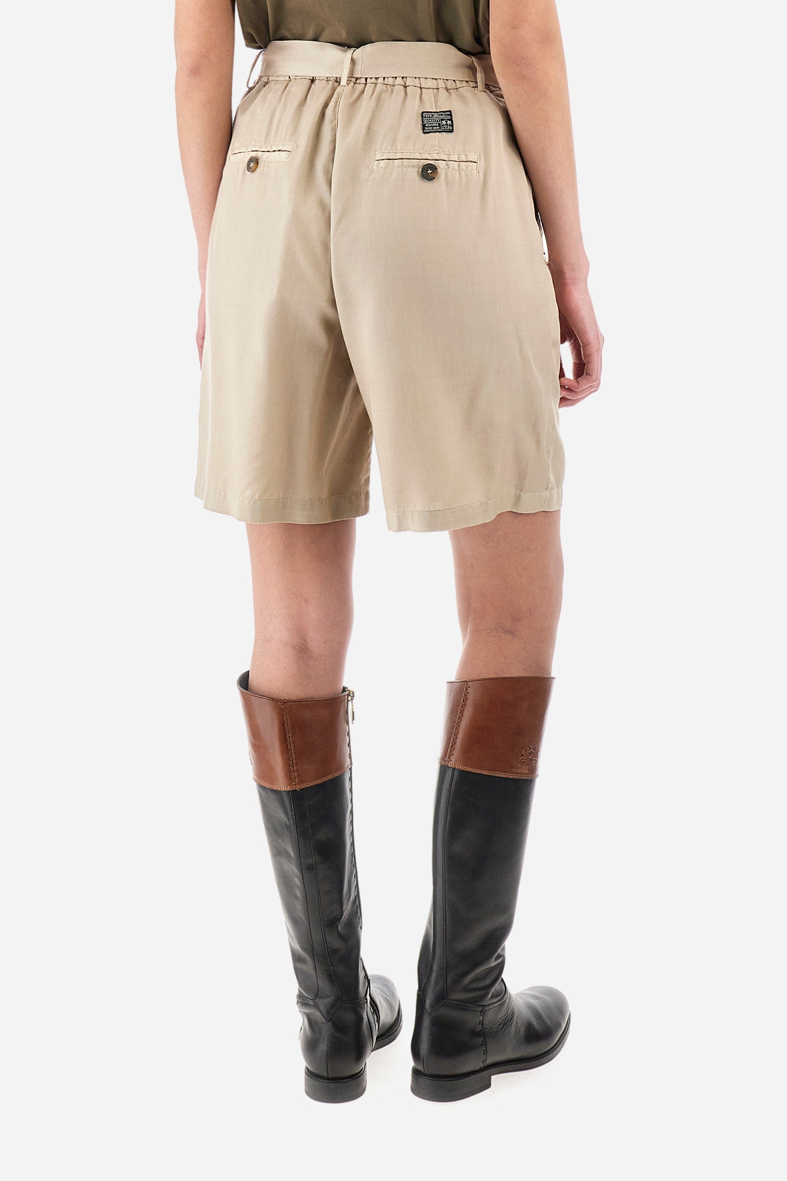 Single-colour women's Bermuda shorts made of eco-friendly fabric. With belt loops, zip and button fastening. Integrated and removable fabric belt. Featuring two open front pockets, with two additional pockets with buttonhole and button fastening on the back. The logo is present on a metal plate on the front and on a patch sewn on the back. The fit is regular. The model wears a size IT 40. - Tidal Foam