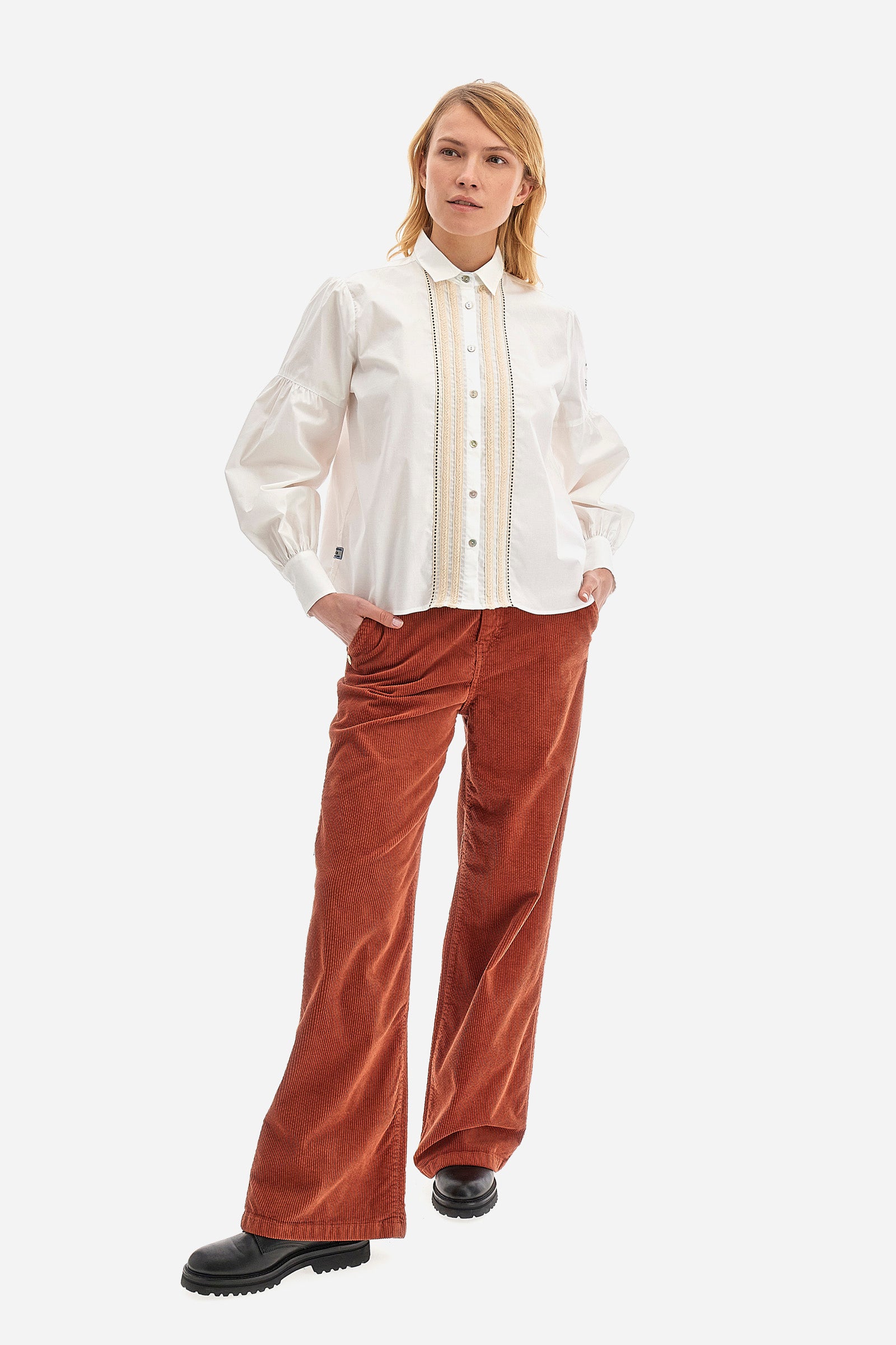 The Argentina women's shirt is made of solid-coloured stretch cotton, with an elegant regular fit. The design features a refined classic collar and button fastening with cable and openwork trims, giving the shirt a distinctive edge. The long sleeves, adorned at the top with a balloon effect, give the shirt a delicate and romantic look. Finally, the LM logo applied the sleeve completes the garment with a sophisticated and contemporary aesthetic. The model is 174 cm tall and wears a size 2. - Optic White