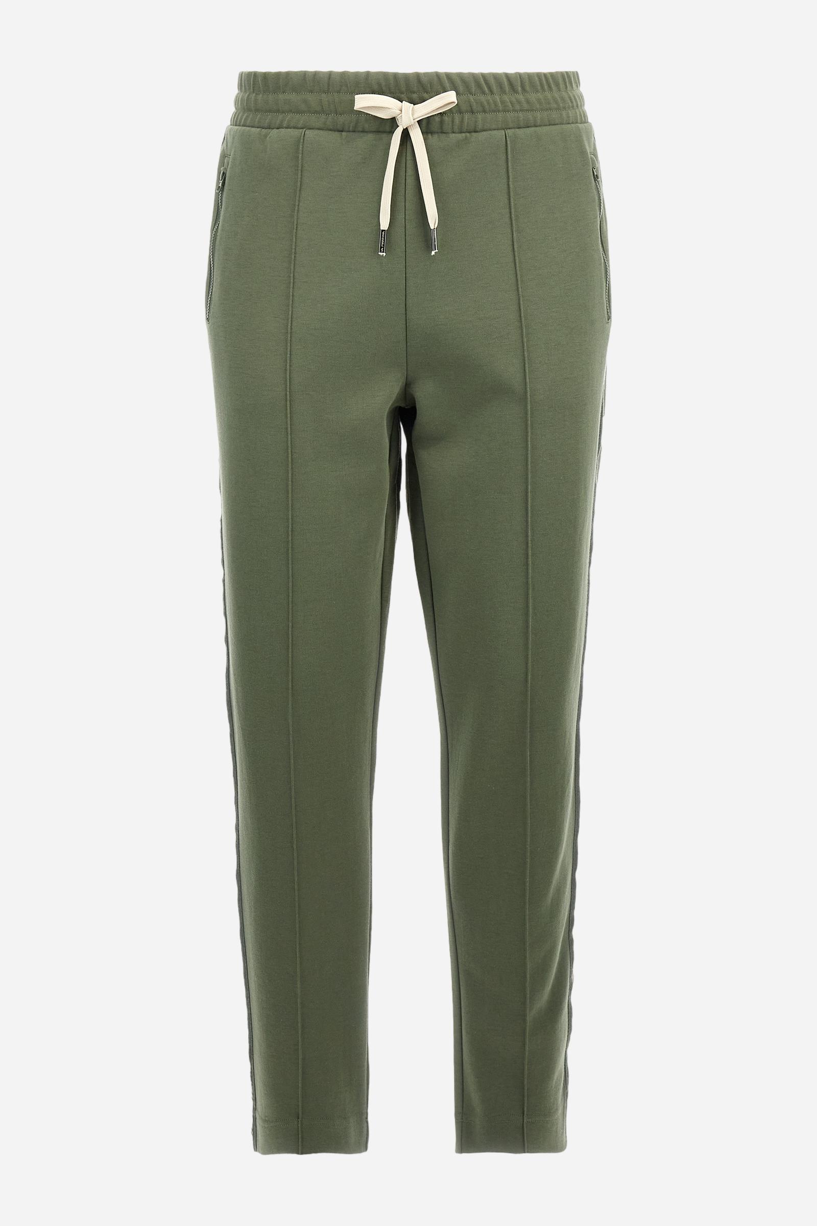 Single-colour men's jogging trousers made of lightweight cotton-blend interlock fleece. Drawstring waistband. Side pockets with matching zip fastening. On both sides, there are multicoloured striped jersey bands. The front features vertical ribbed detailing. The logo is embroidered in colour-contrasting thread on the back, under the strap, towards the right side. Regular fit. The model is wearing a size L. - Thyme