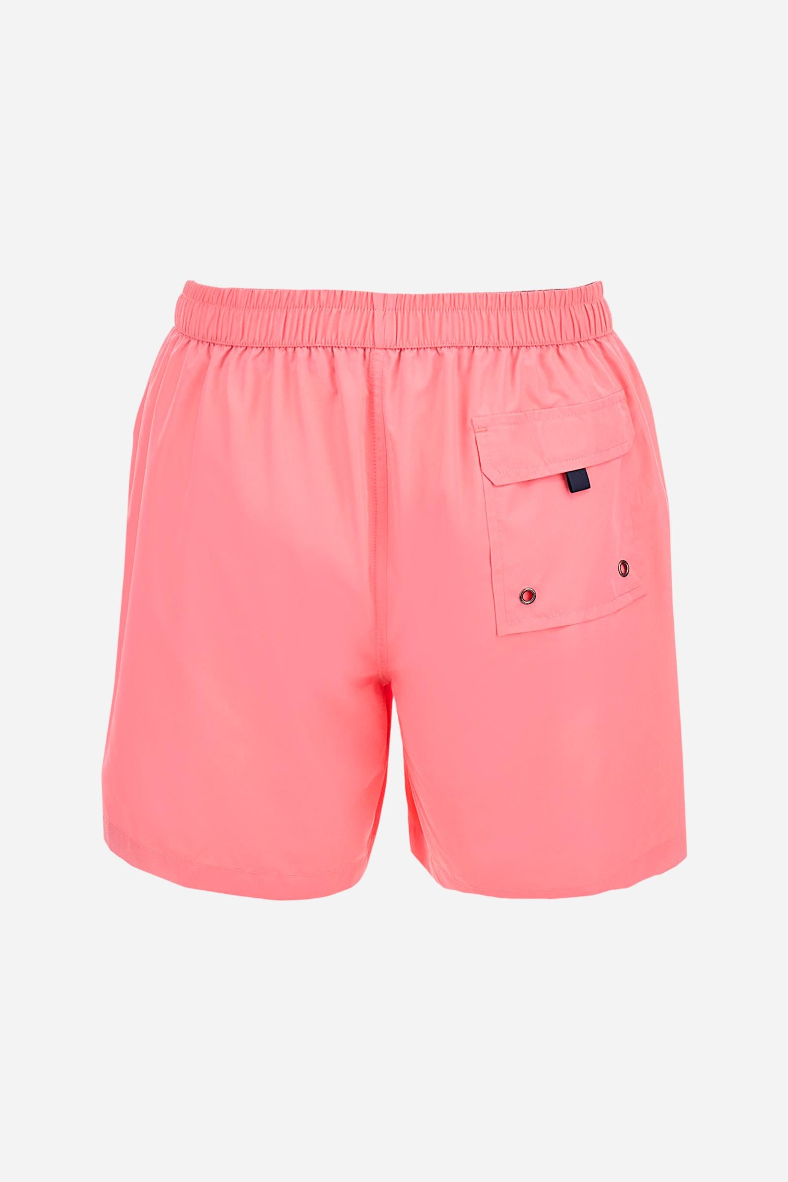 Plain men's swimming shorts made of nylon. Elastic waistband with a personalised drawstring for waist adjustment. On the inside of the shorts is an elasticated mesh brief. Double side pocket on the hips and patch pocket with flap on the back, on the right side only. The large logo is embroidered in a contrasting colour thread on the bottom of the left leg on the front. Regular fit. The model is wearing a size L. - Pink Lemonade