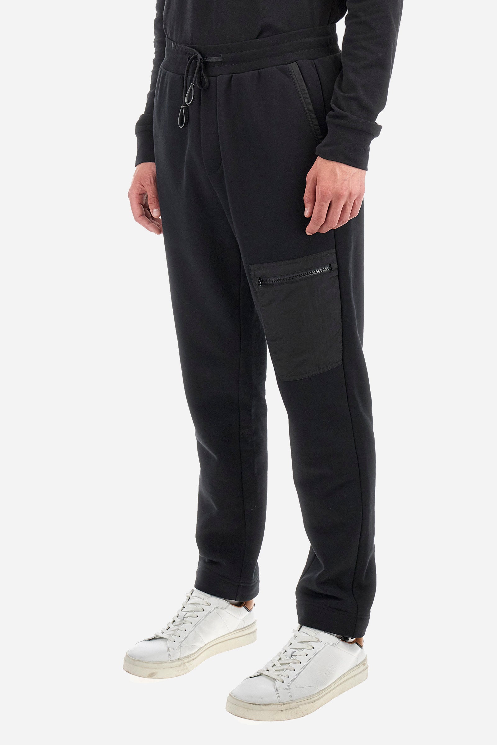 Men's plain jogging bottoms, made from a cotton blend. Drawstring waist and cuffs. Double front pocket. There is an additional zipped pocket on the front. The logo appears on an appliquéd plaque the back. Regular fit. The model is wearing a size L. - Black