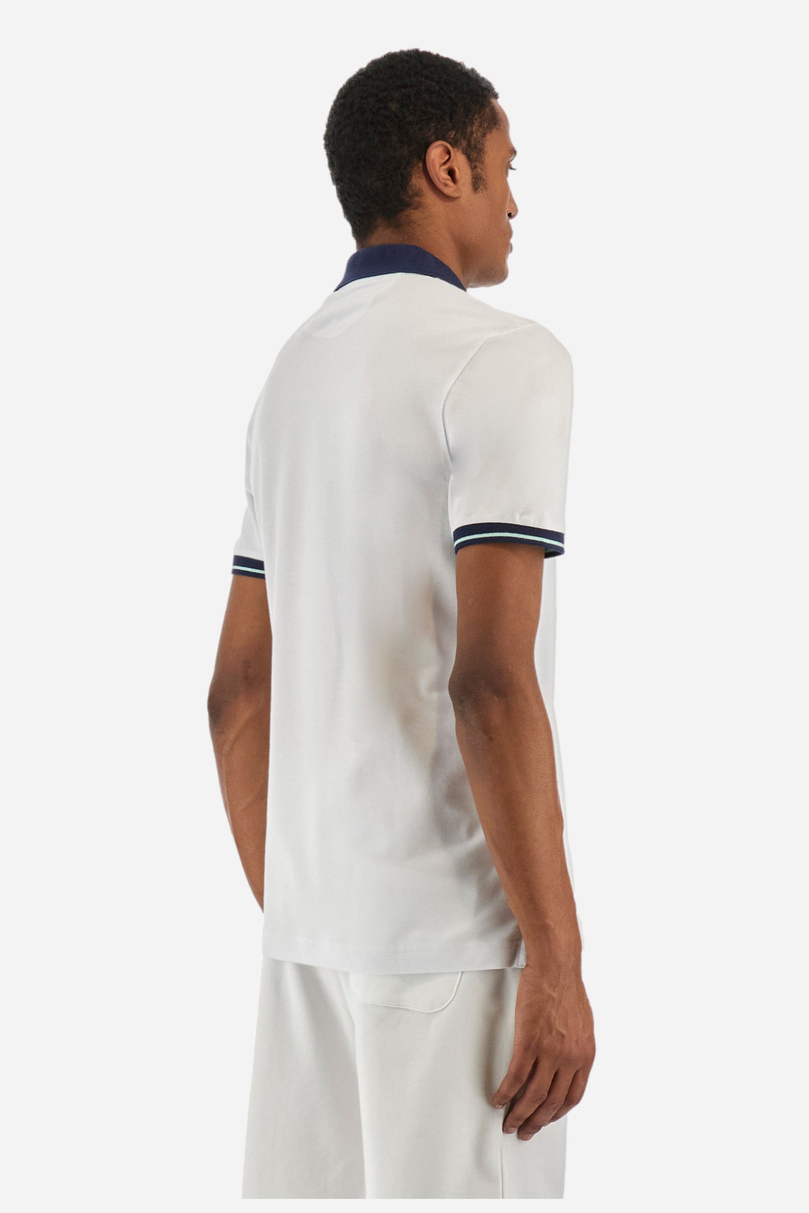 Men's single-colour short-sleeved polo in elasticated cotton. Fastens with two contrasting buttons. Ribbed collar and armholes in different shades. The "La Martina" lettering can be found under the collar. A large logo is embroidered on the chest. The fit is slim. The model wears a size L. - Optic White
