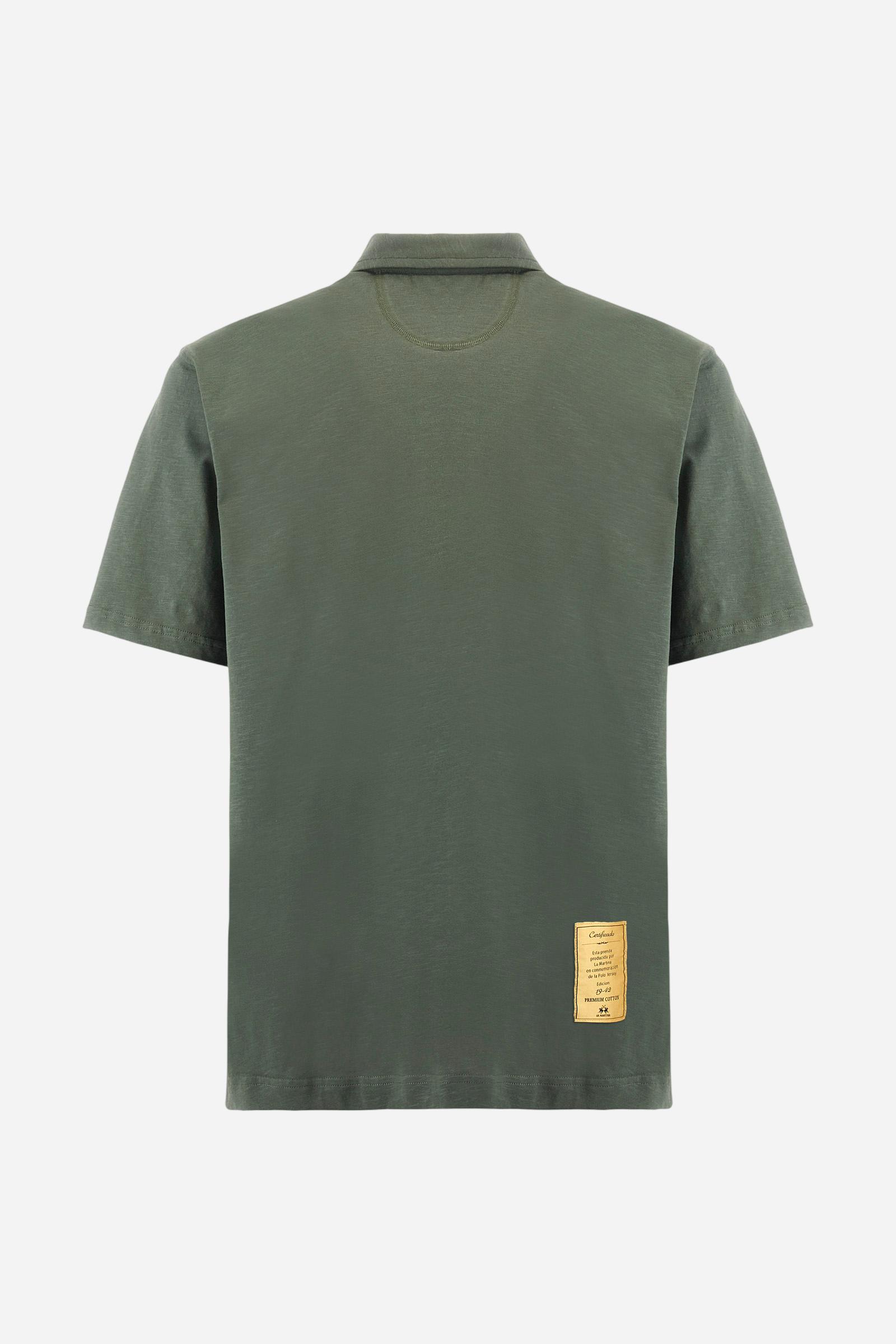 Men's short-sleeved polo shirt in a single colour, made of 100% cotton slub jersey. Fastens with a button. A fabric patch representing the garment's certificate is sewn onto the back. The logo is embroidered in contrast under the opening on the front. Comfort fit. The model is wearing a size L. - Thyme
