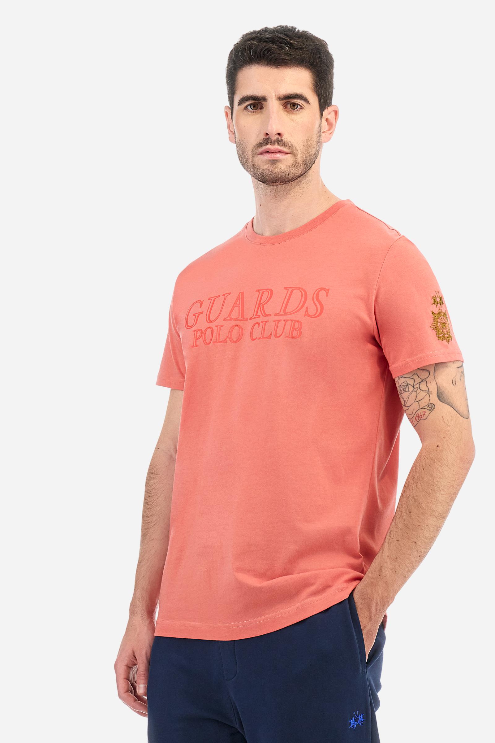 Men's solid color Guards T-shirt, made of cotton jersey. Crew neck. The front features a rubberized print of the line's name. On the left sleeve, the Guards emblem and the brand's logo are embroidered. The fit is regular. The model is wearing size L. - Spiced Coral