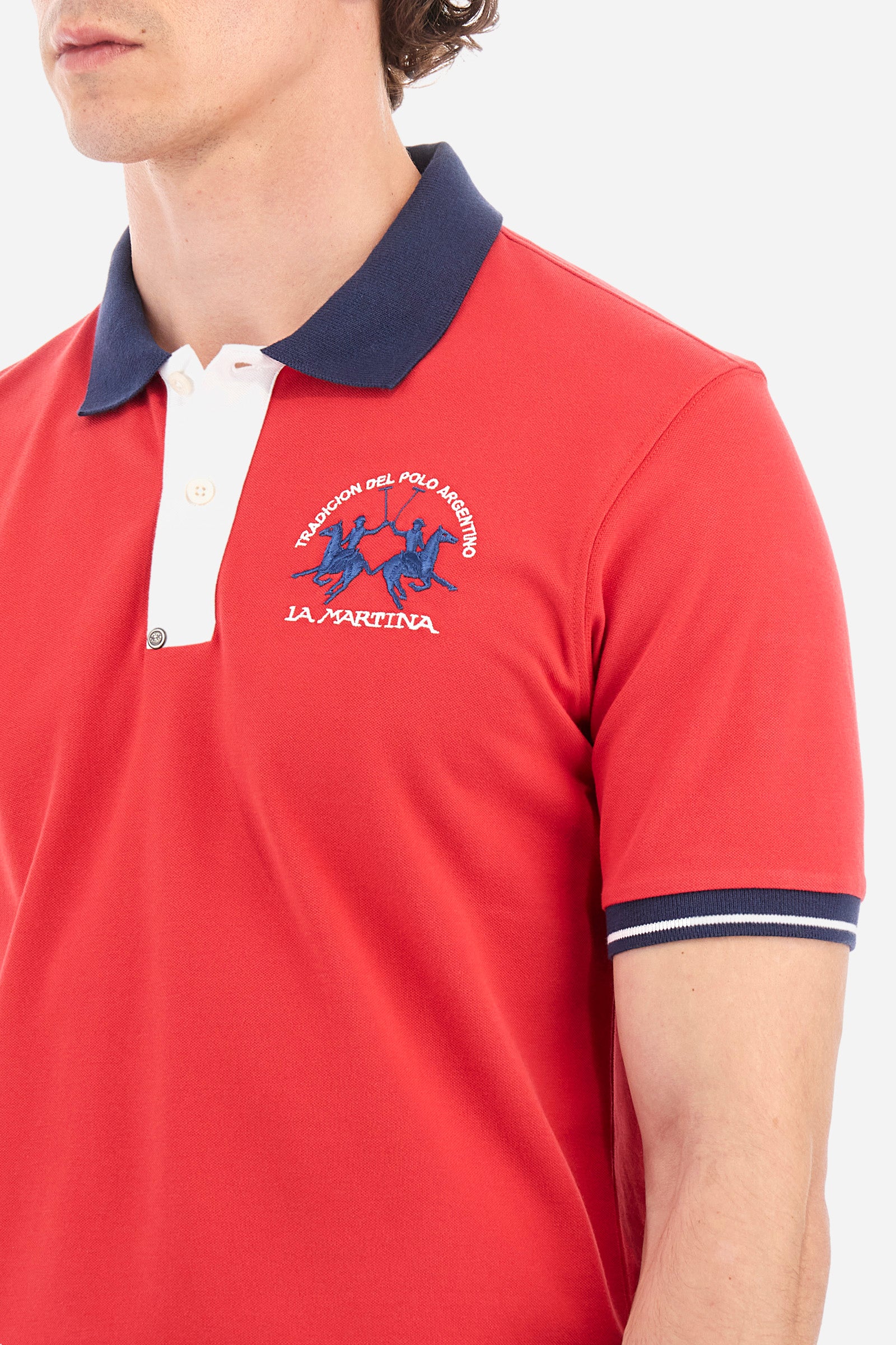 Men's single-colour short-sleeved polo in elasticated cotton. Fastens with two contrasting buttons. Ribbed collar and armholes in different shades. The "La Martina" lettering can be found under the collar. A large logo is embroidered on the chest. The fit is slim. The model wears a size L. - Formula One