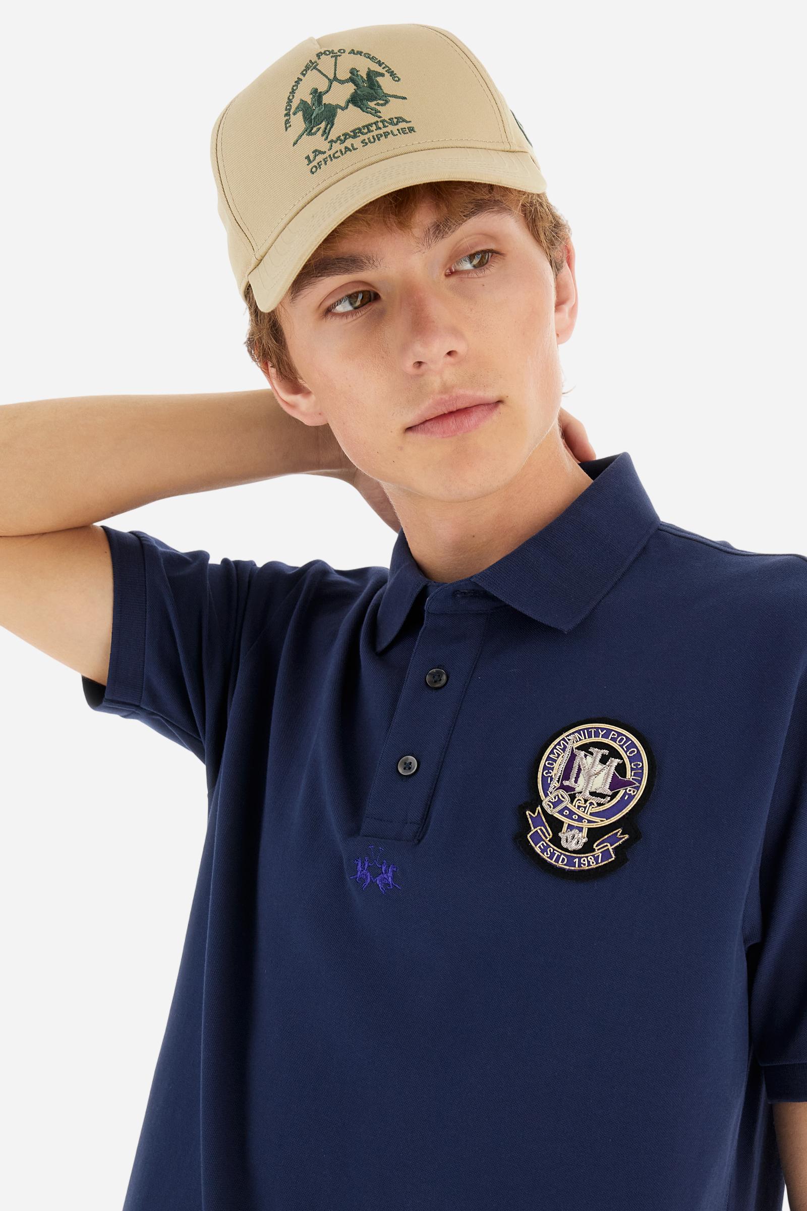 Men's short-sleeved polo shirt in a single colour, made of cotton stretch pique. Fastens with three buttons. Cuffs and collar in rib knit to match the garment. Patch in metallic thread applied on the chest. A colour-contrasting logo is present on the front. Regular fit. The model is wearing a size L. - Navy