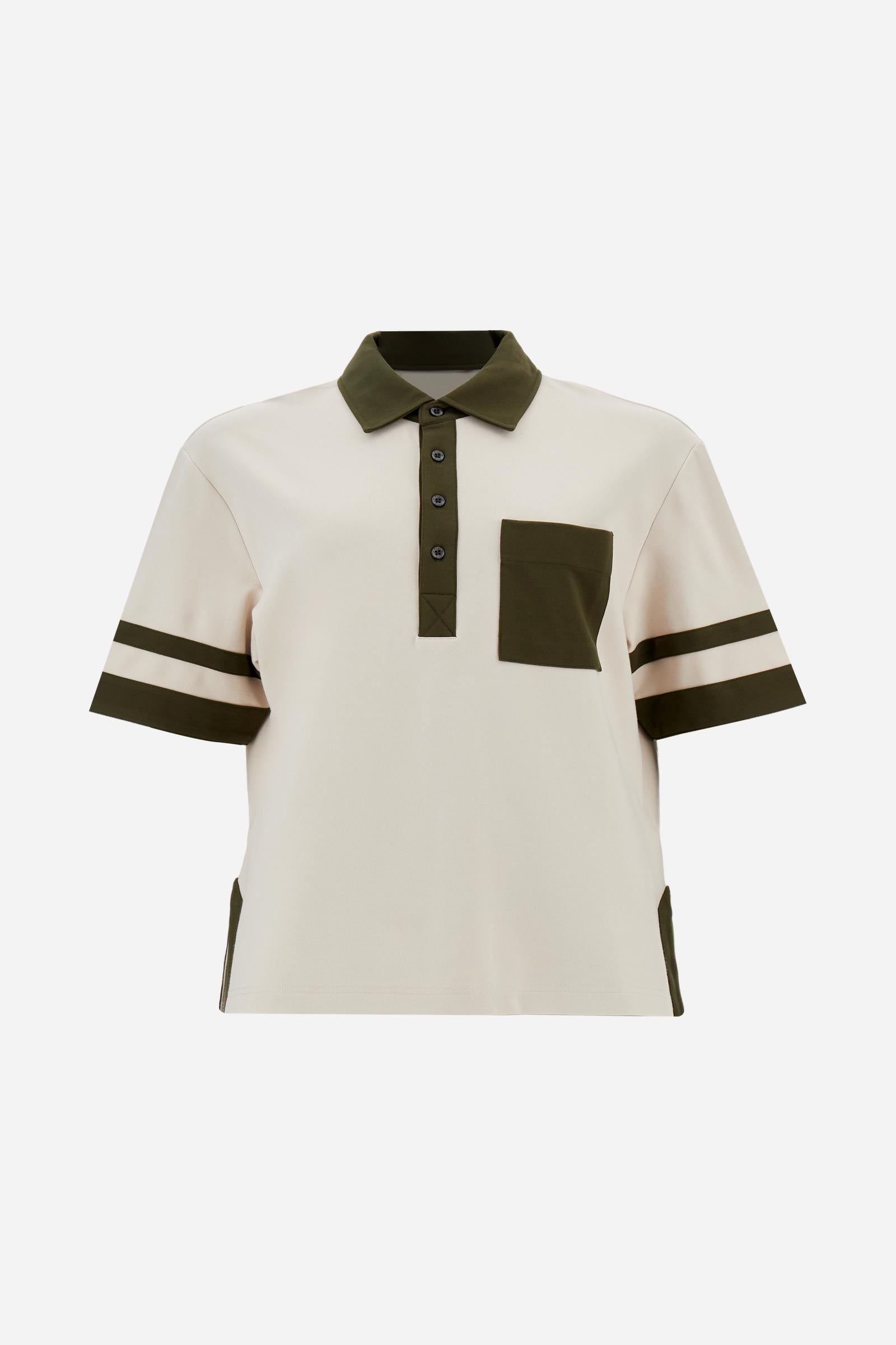 Women’s short-sleeve polo shirt in high-quality solid-colour viscose blend interlock. Classic collar with deep three-button placket, contrast fabric details on body and sleeves. Large embroidered logo on the back. Boxy, straight fit at the hips for a modern and comfortable silhouette. The model wears size L. - Creme Brulè/Kombu Gr