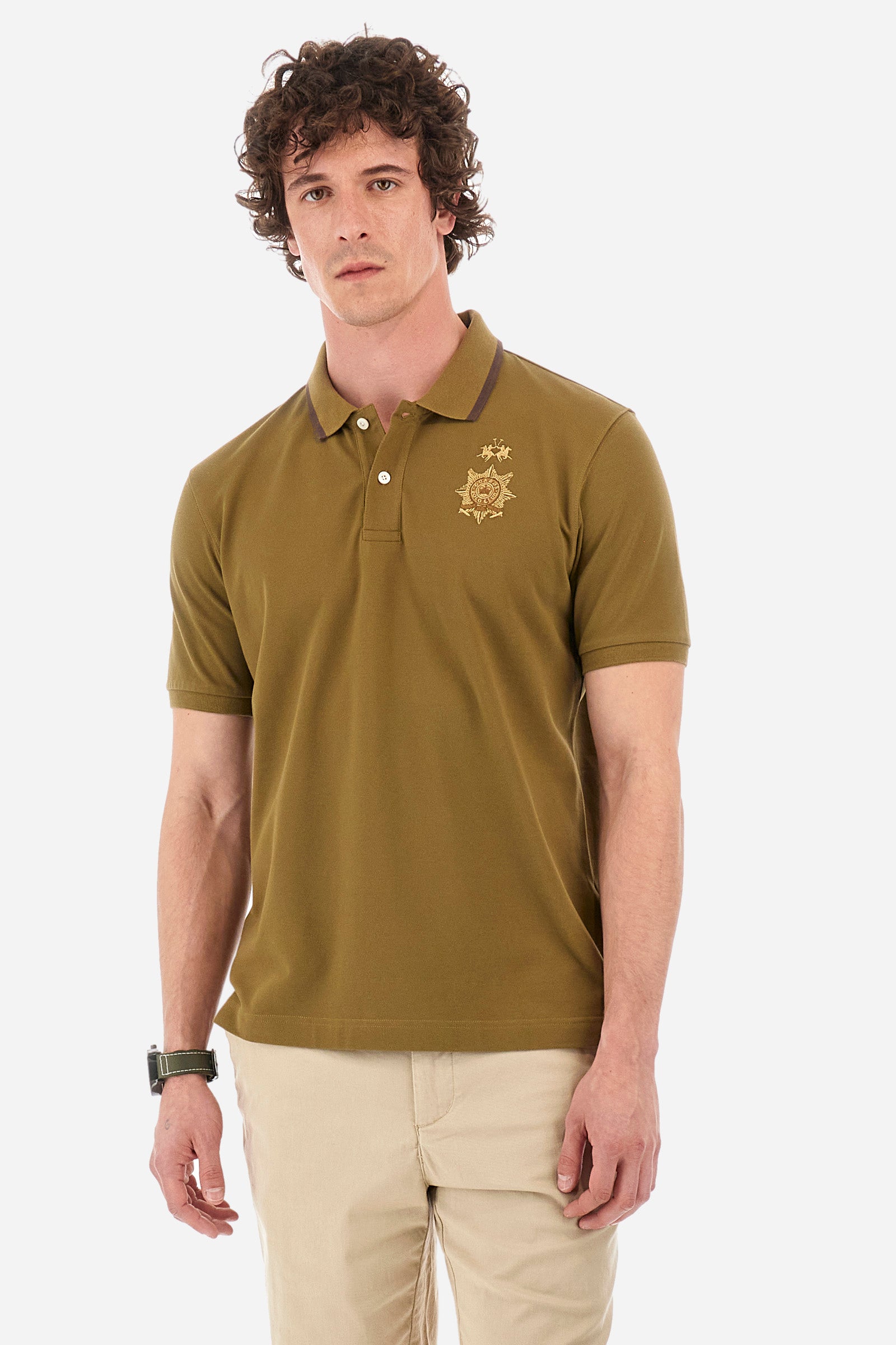 Men's short-sleeved single-colour polo shirt in elasticated cotton. Two-button fastening. Ribbed collar and armholes. The neck is profiled. On the front we find the symbol representing the Guards line. Featuring a small logo embroidered on the chest. The fit is regular. The model wears a size L. - Military Olive