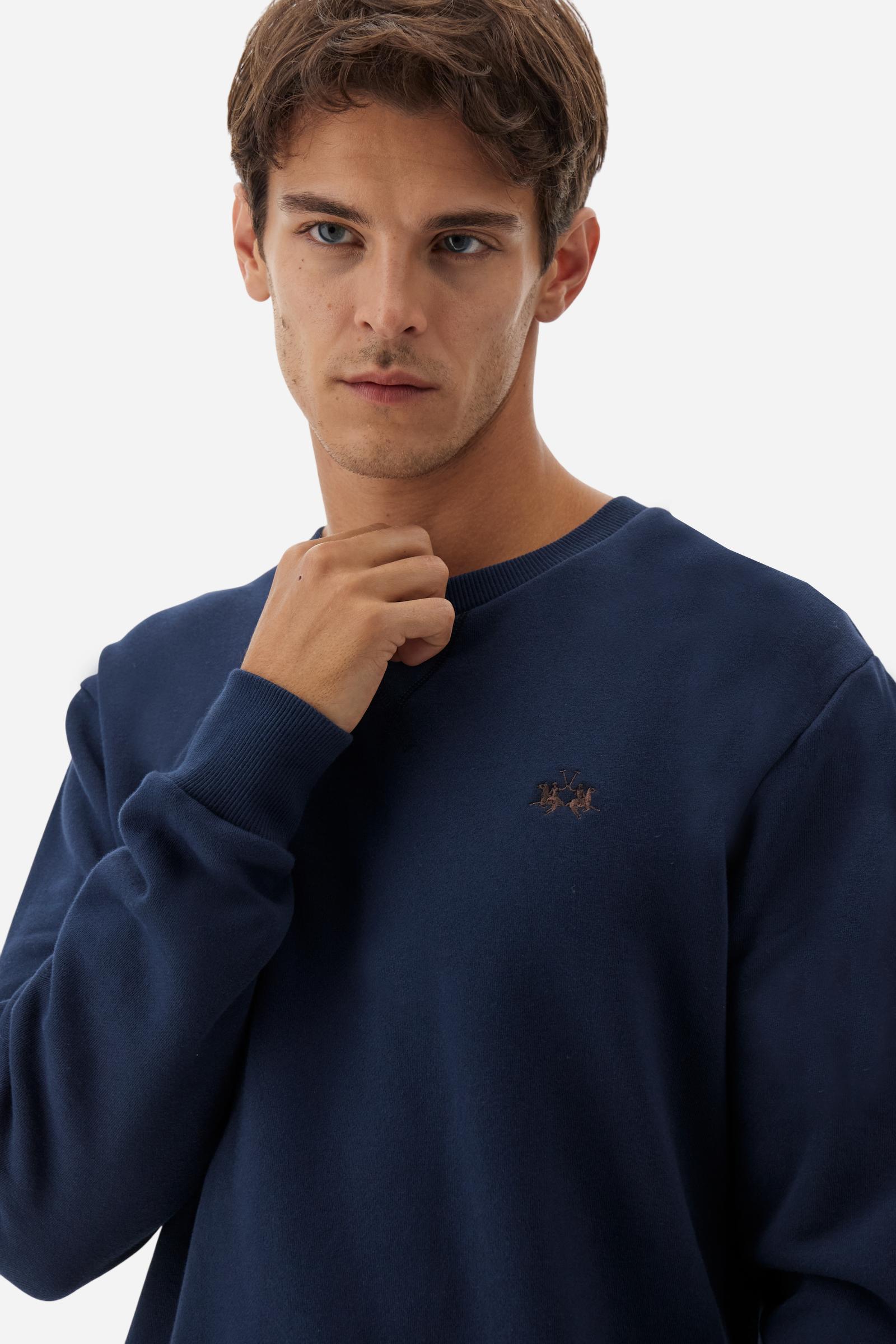 Men's long-sleeved round neck sweatshirt in 100% cotton fleece with a velvety feel. The collar, cuffs, waist and sides are in matching ribbed knit. The small brand logo is embroidered in contrasting colour on the chest. This essential piece has a regular fit for a timeless silhouette. The model is wearing a size L - Navy