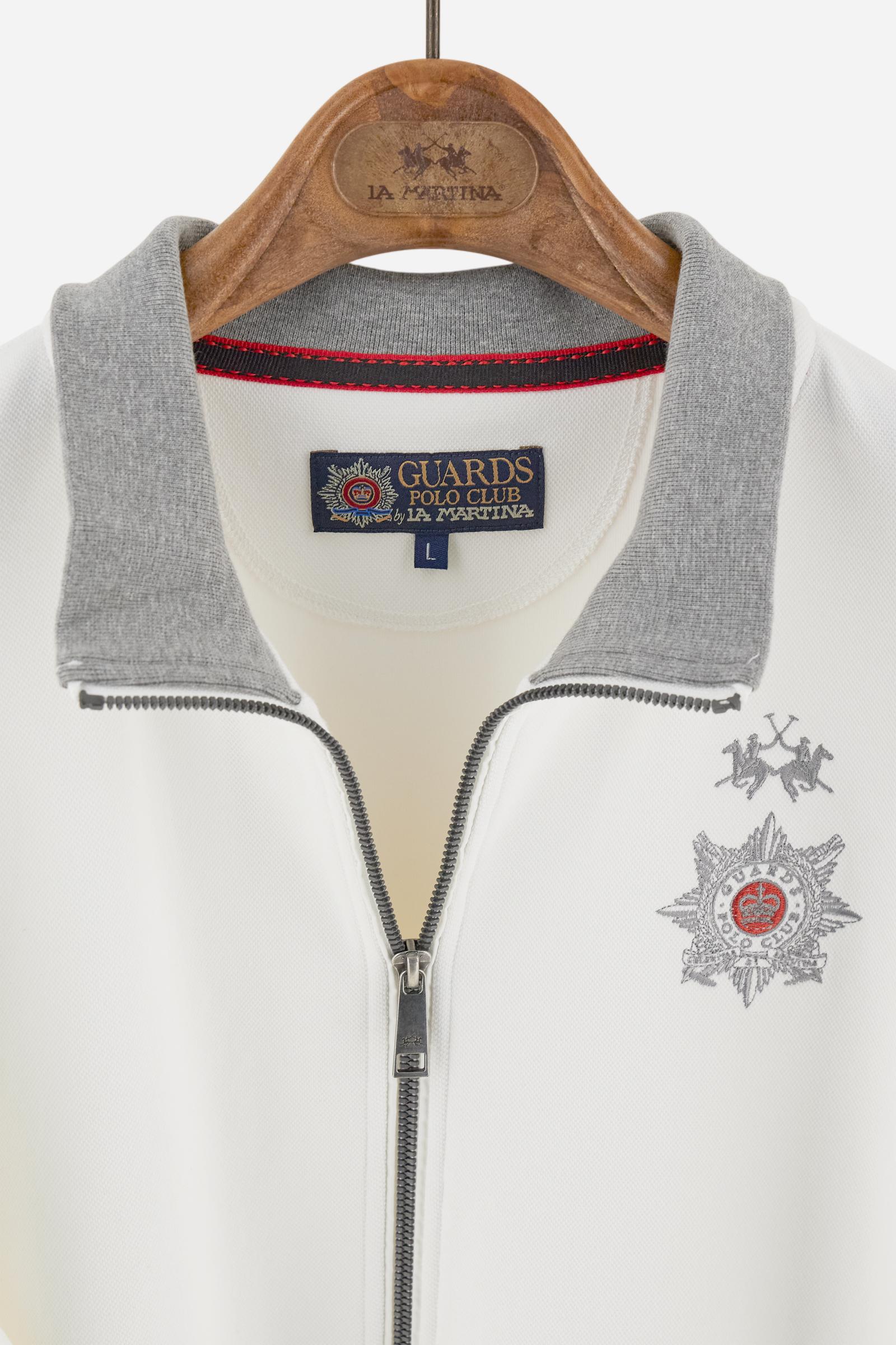 Men's long-sleeved, full-zip solid colour sweatshirt. Made of stretch cotton-blend piqué. Design with front opening fastened by a zip, high collar in two-tone ribbing. Solid colour ribbed cuffs and waistband. The small brand logo and Guards crest are embroidered in multi-coloured thread on the chest. On the right sleeve, there is another embroidery of a crest inspired by the British royal household. The regular fit silhouette is practical for everyday wear. The model is wearing a size L. - Off White