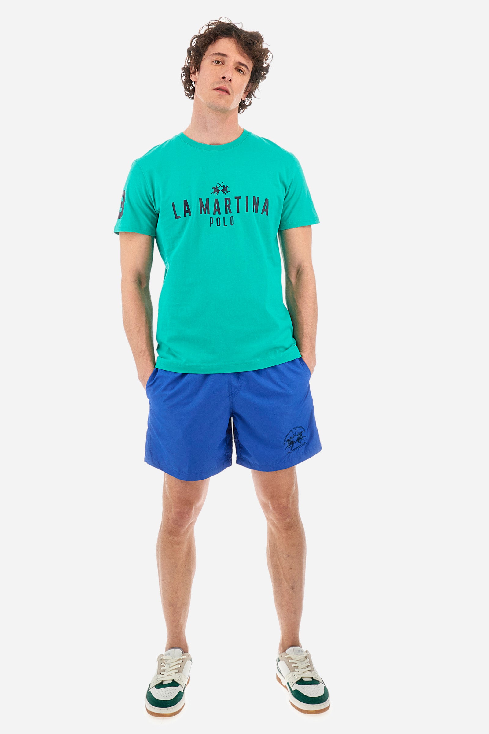 Single-colour men's swimming shorts, made of synthetic fabric. Featuring a drawstring and tie with "La Martina" lettering. Double welt pocket on the front. Closed pocket on the back. Mesh lining. Large logo embroidered on the front. The fit is regular. The model wears a size L. - Olympian blue