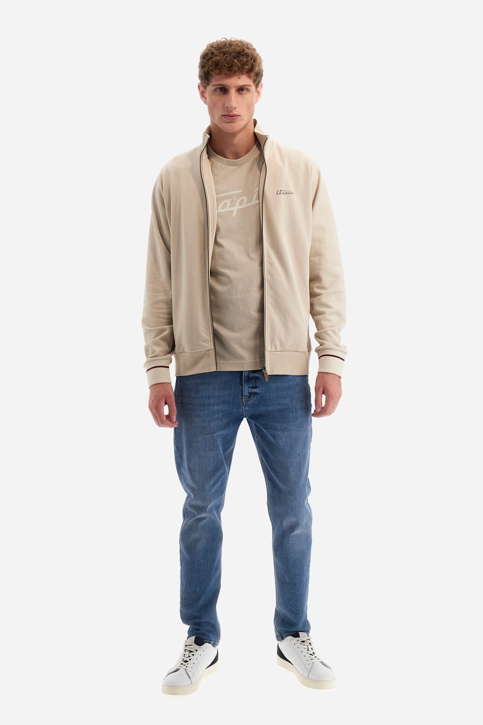 Single-colour long-sleeved men's sweatshirt with full zip fastening from the line in collaboration with Pagani. Made of 100% cotton. Mock neck, ribbed waistband and cuffs. Double back pocket. On the sides the garment has a different texture from the main part. There is lettering on the front, while a plate featuring the La Martina logo and the Pagani logo is sewn on the back. The fit is regular. The model wears a size L. - Rainy Day