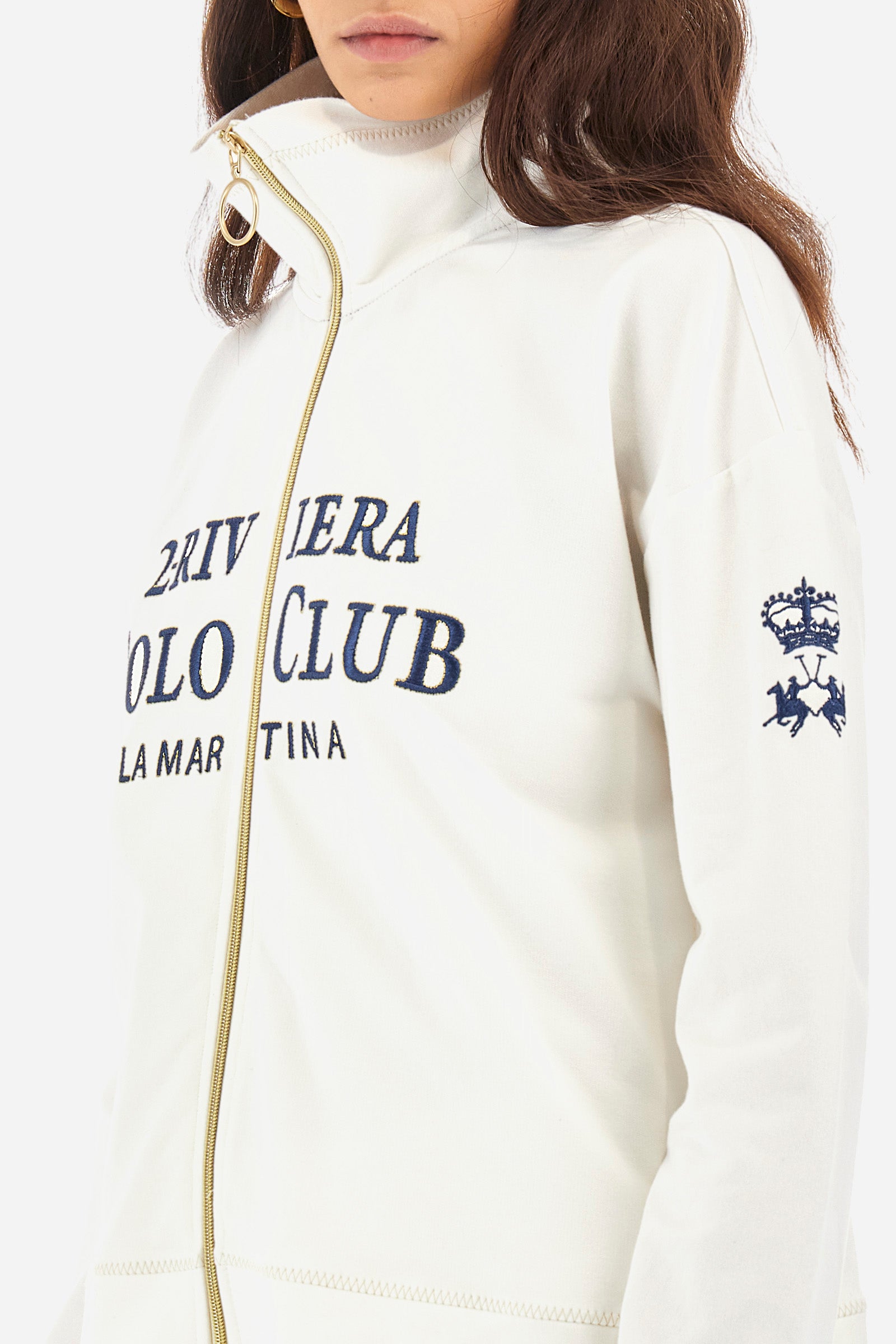 Women’s sweatshirt with long sleeves in solid color with full zip closure in contrasting tone. Made of stretch cotton. Wide neck, can be zipped up high. Contrasting embroidered lettering and logos on the front and sleeves recall the Polo Club Grand Hotel capsule collection. Regular fit. The model wears a size 2. - Off White