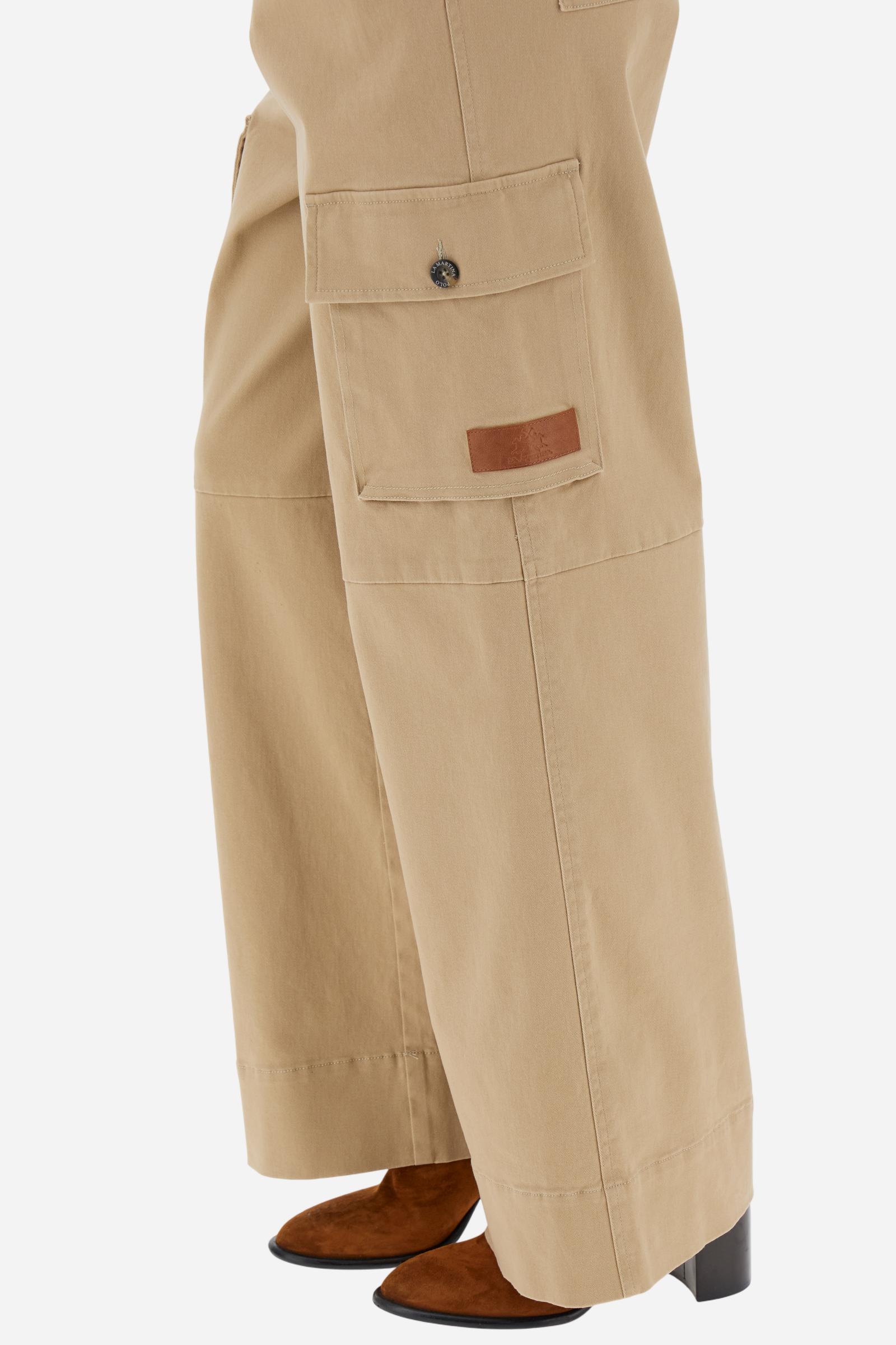 Women’s long cargo trousers in stretch cotton twill with front zip and internal hook closure. Side slash pockets and large applied thigh pockets with flap and personalised horn-effect buttons, also repeated on the back as a detail. Logo on faux leather label applied to the left thigh pocket. Relaxed fit with wide, straight leg. The model wears size 2. - Travertine