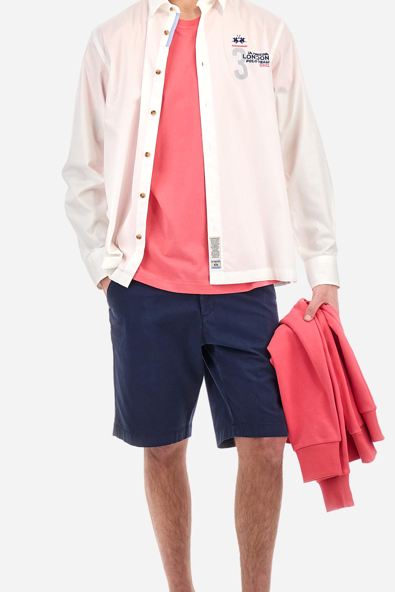 Men's single-colour long-sleeved shirt, made from 100% cotton poplin. Spread collar. Contrasting printed fabric details on the inside of the collar and opening. The numbers on the chest and back graphics are rubberised prints, while the rest of the graphics are embroidered. The logo and La Martina lettering is embroidered on the left chest. The fit is regular. The model is wearing a size L. - Optic White