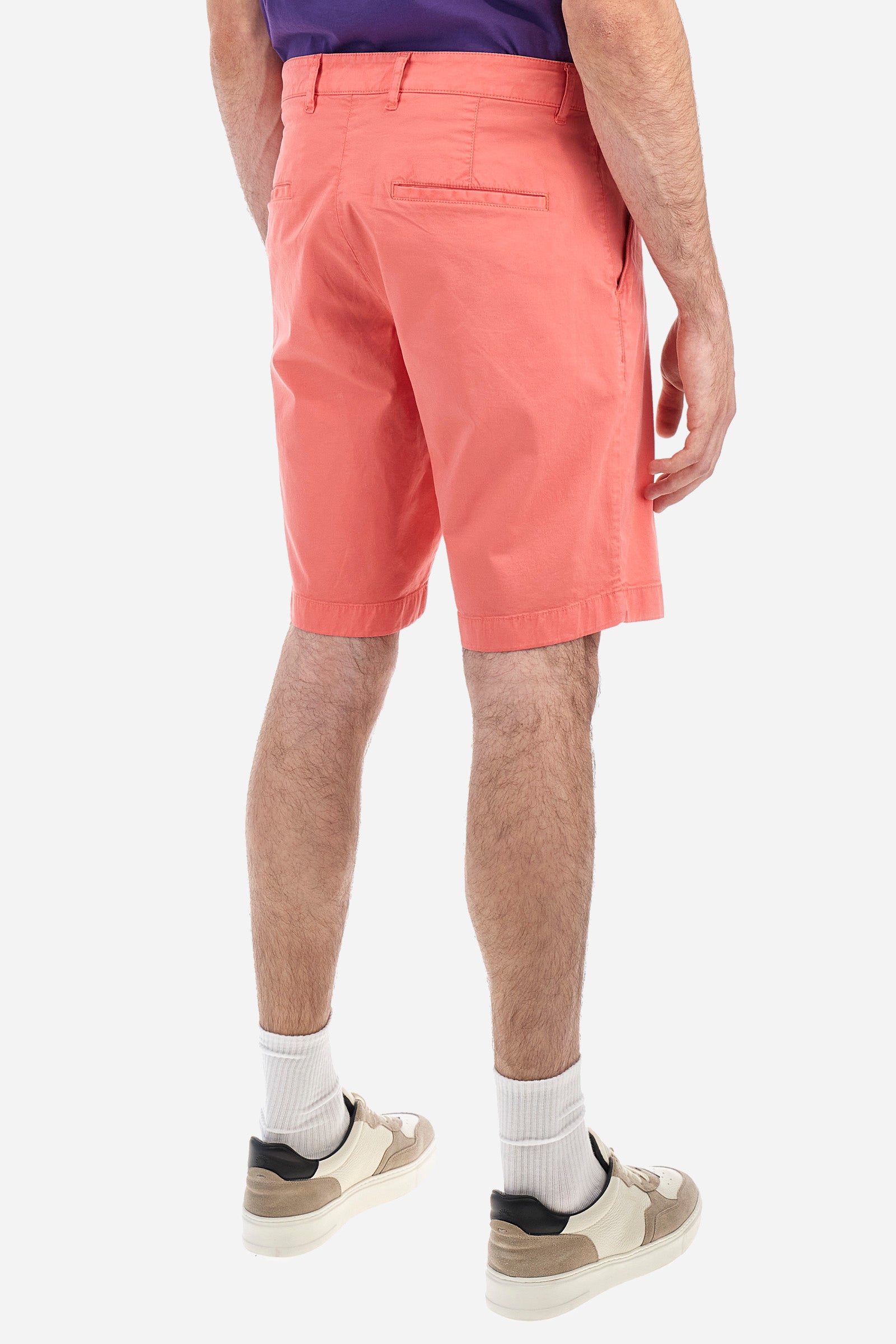 Men's plain Bermuda shorts made from cotton twill. Fastened with a zip and faux horn button, they feature side slash pockets to complete the sleek and functional design. A handy welt coin pocket is located under the waistband on the right side. On the back, welt pockets continue the clean, elegant style. A tone-on-tone embroidered logo appears under the waistband at the opening of the right pocket. Regular fit. The model is wearing a size 33. - Spiced Coral