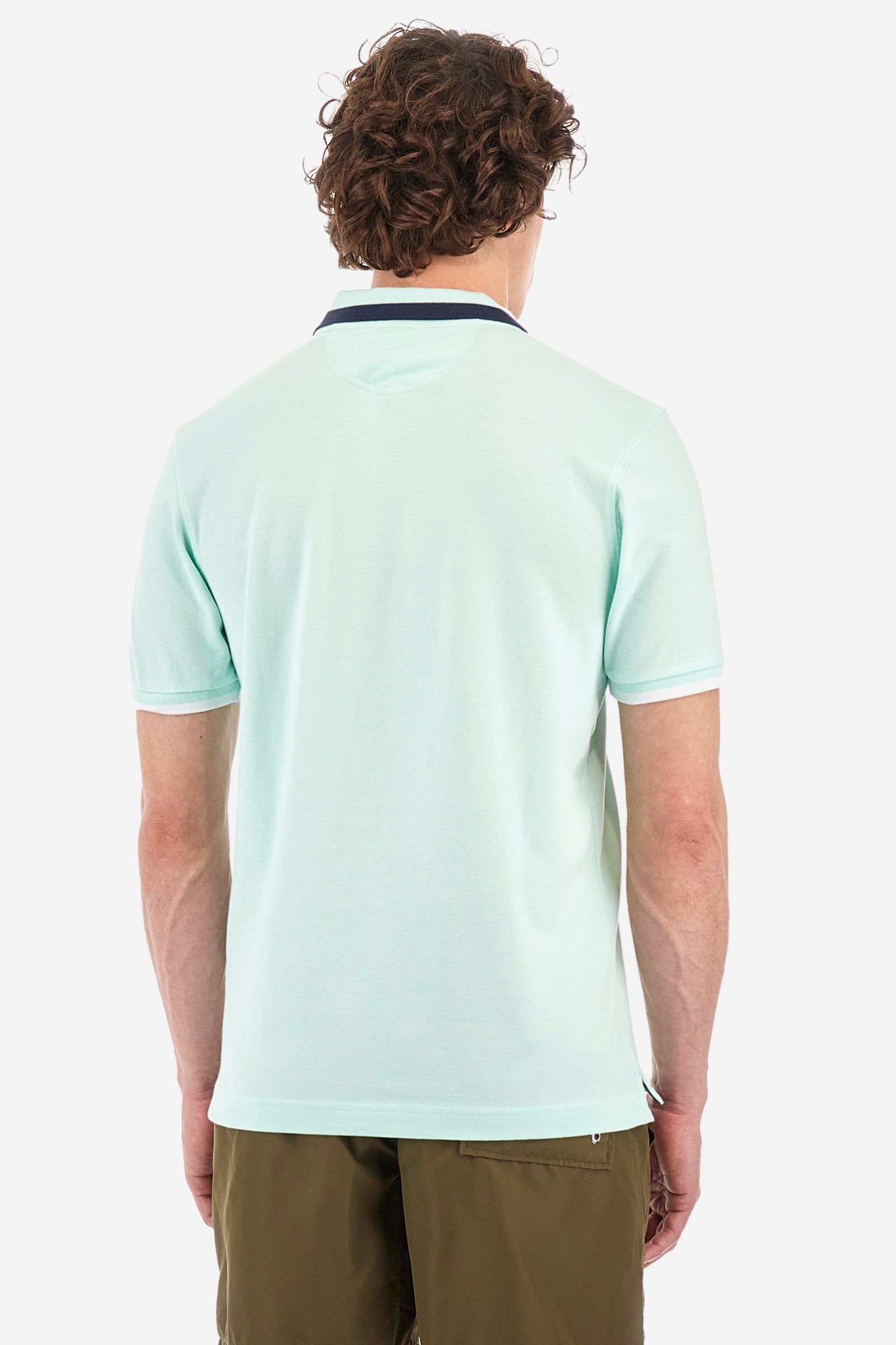 Men's single-colour short-sleeved polo in elasticated cotton. Two-button fastening. Ribbed collar and armholes with a stripe in different shades. The "La Martina" lettering can be found under the collar. Featuring a small logo embroidered on the chest. In a slim fit. The model wears a size L. - Honeydew