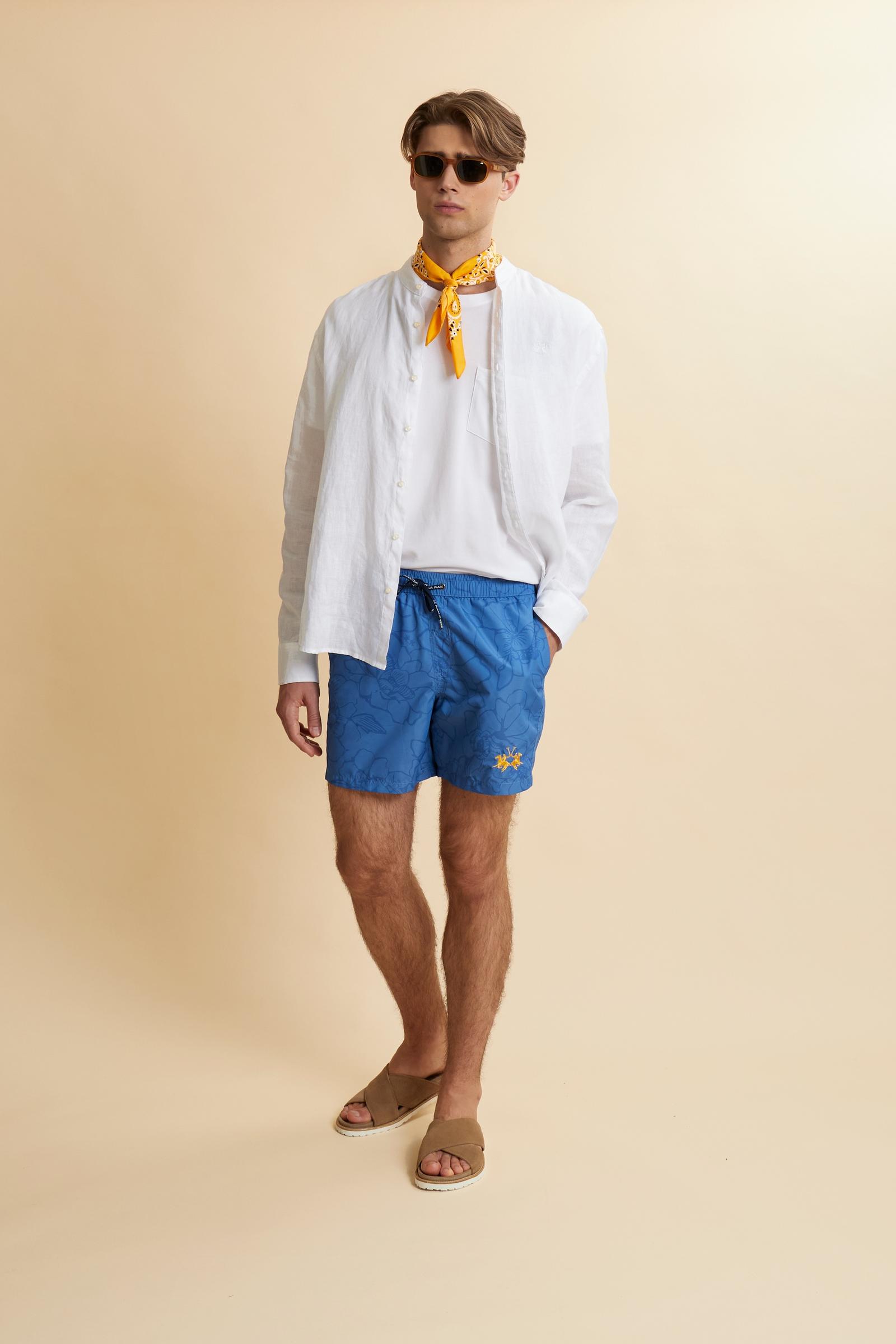 Men’s nylon swim shorts with floral print. Mid-length design with elasticated waistband, drawstring and contrasting embroidered logo. - Riviera/Dutch Blue