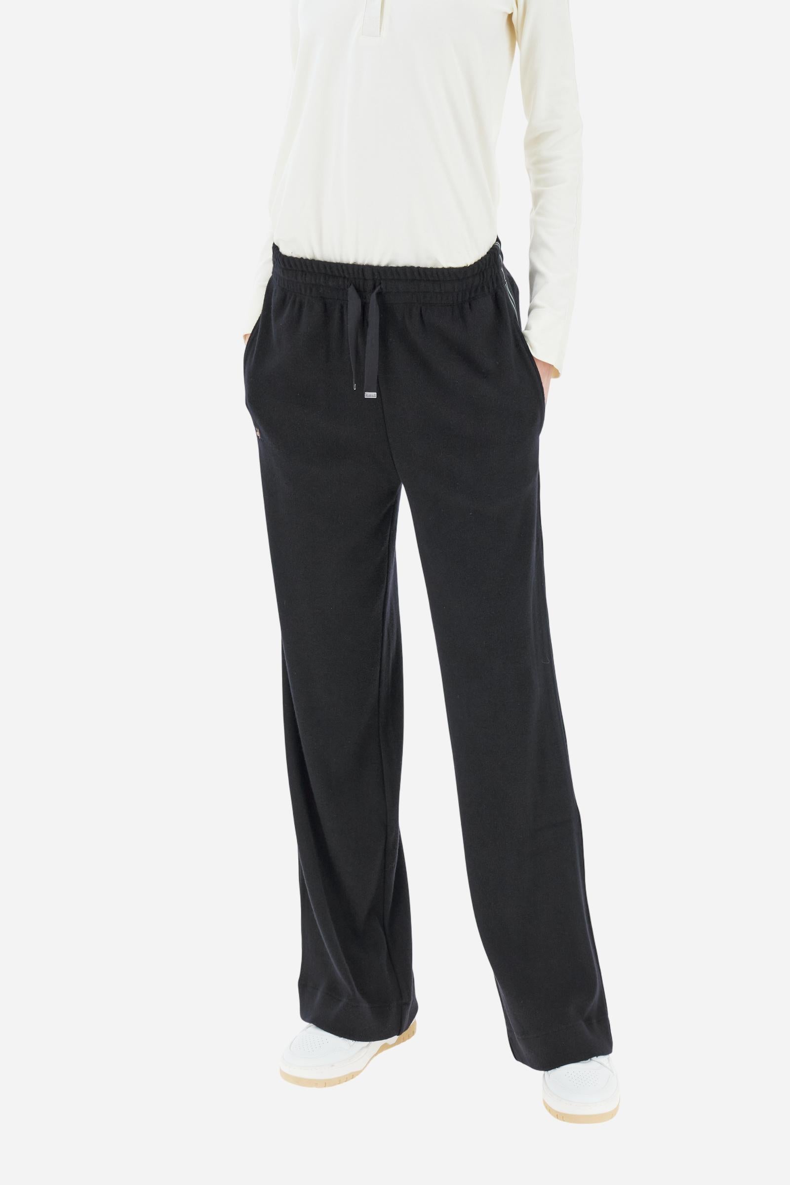 Women’s pants made of viscose-blend interlock fleece, soft and luxurious on the skin. Elastic waistband with adjustable drawstring ensures optimal comfort. Side pockets and bicolor striped tape along the sides complete the design. A small tonal embroidered logo enriches the front. Straight leg with slightly flared hem for a feminine, elegant twist in athleisure style. Model wears size 2. - Black