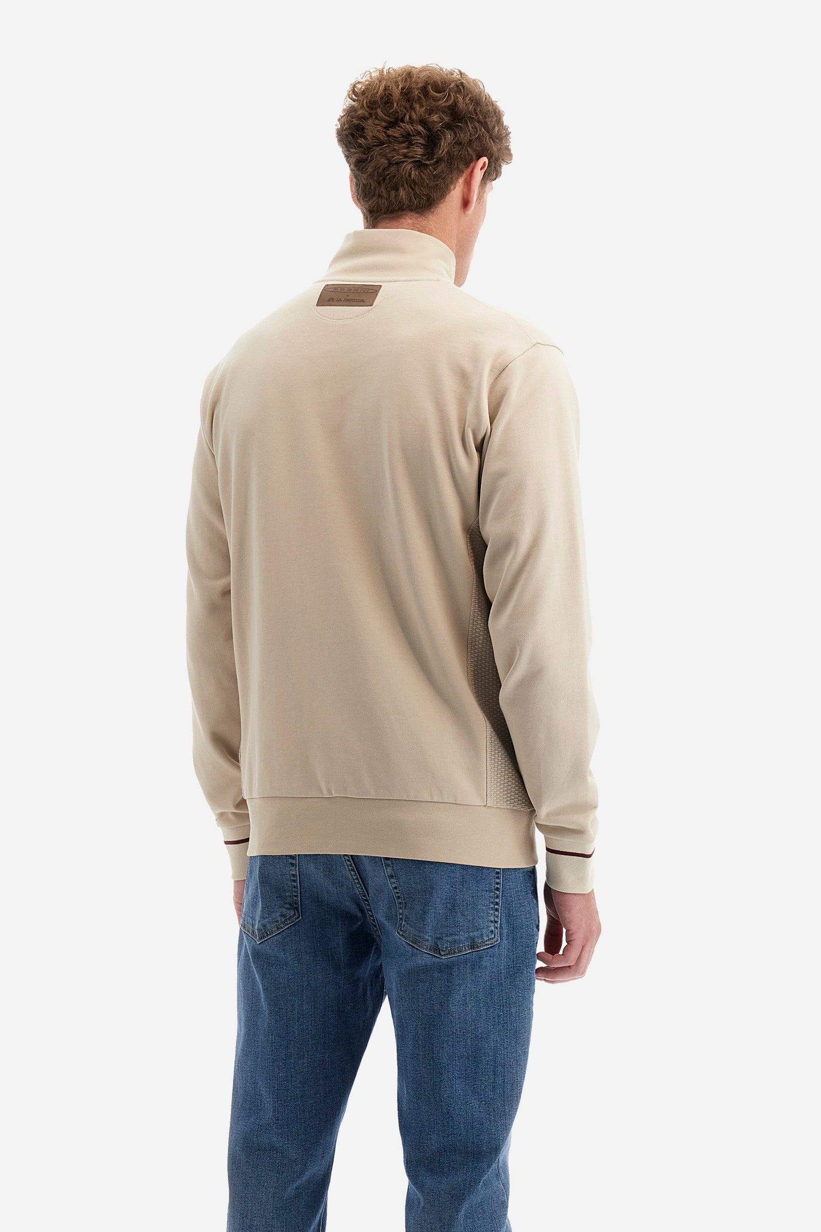 Single-colour long-sleeved men's sweatshirt with full zip fastening from the line in collaboration with Pagani. Made of 100% cotton. Mock neck, ribbed waistband and cuffs. Double back pocket. On the sides the garment has a different texture from the main part. There is lettering on the front, while a plate featuring the La Martina logo and the Pagani logo is sewn on the back. The fit is regular. The model wears a size L. - Rainy Day